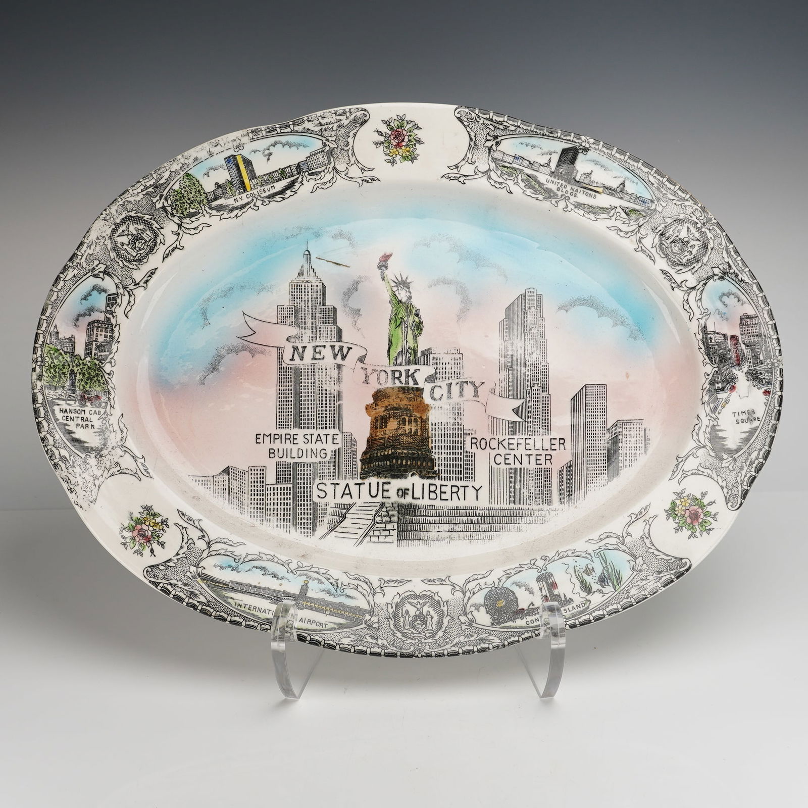 New York City Ceramic Souvenir Wall Platter: The platter features a molded, scalloped rim and is decorated using transfer-printing and polychrome enamel highlights. The central well depicts the New York City skyline, highlighted by the Statue of
