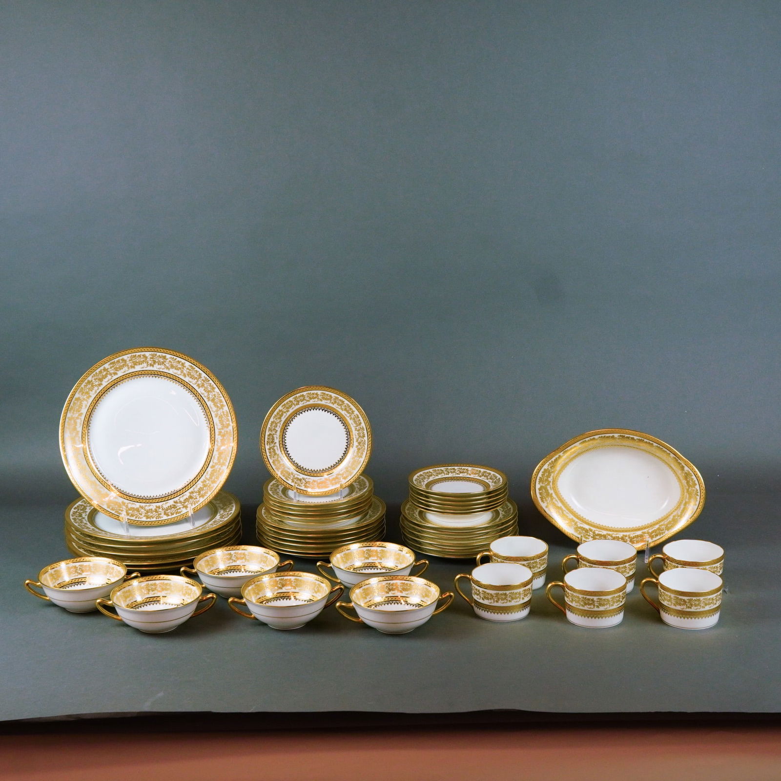 43pc. Charles Field Haviland Limoges Porcelain Dinner Service: A 43-piece partial dinner service manufactured by Charles Field Haviland, Limoges, crafted from fine translucent white porcelain. The set is decorated in the opulent Incrustation pattern, featuring a