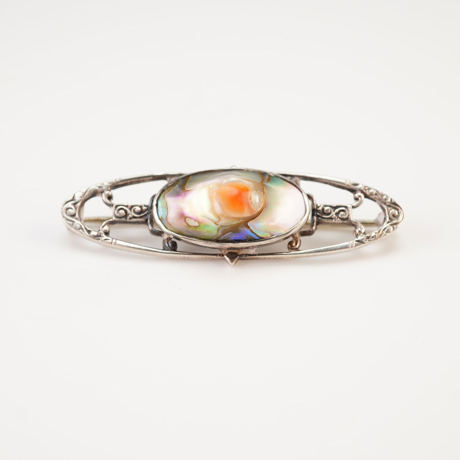 Sterling Silver and Abalone Blister Pearl Bar Brooch: The piece is centered by a large, oval abalone blister pearl cabochon that displays a vibrant play of color, including a prominent iridescent orange center surrounded by pink, green, and blue hues.
