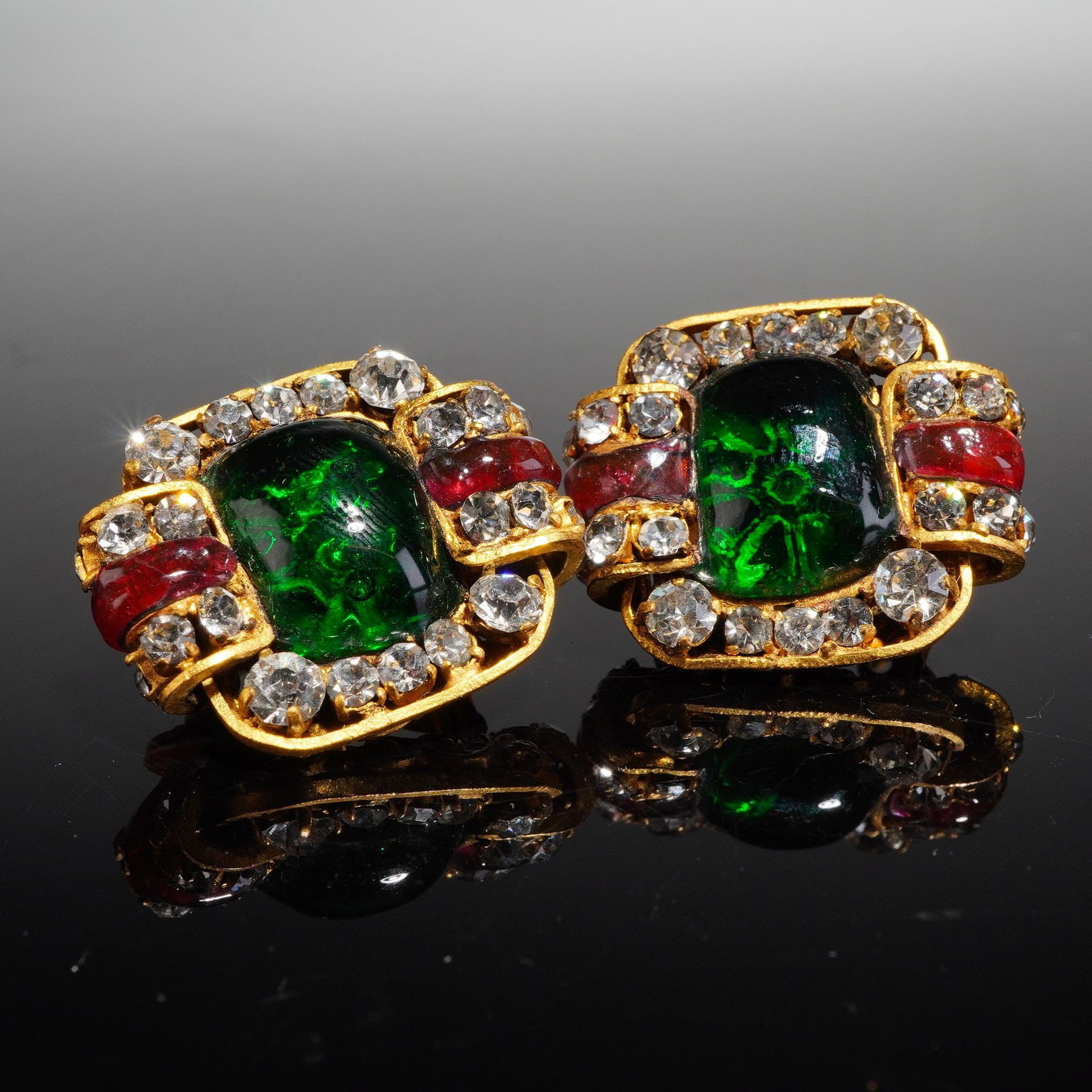 Pair of Chanel Gripoix Red and Green Glass Clip Earrings: A pair of vintage Chanel clip back earrings, attributed to the 1980s period and featuring the use of poured glass, commonly known as Gripoix. The highly dimensional, baroque style settings are crafted
