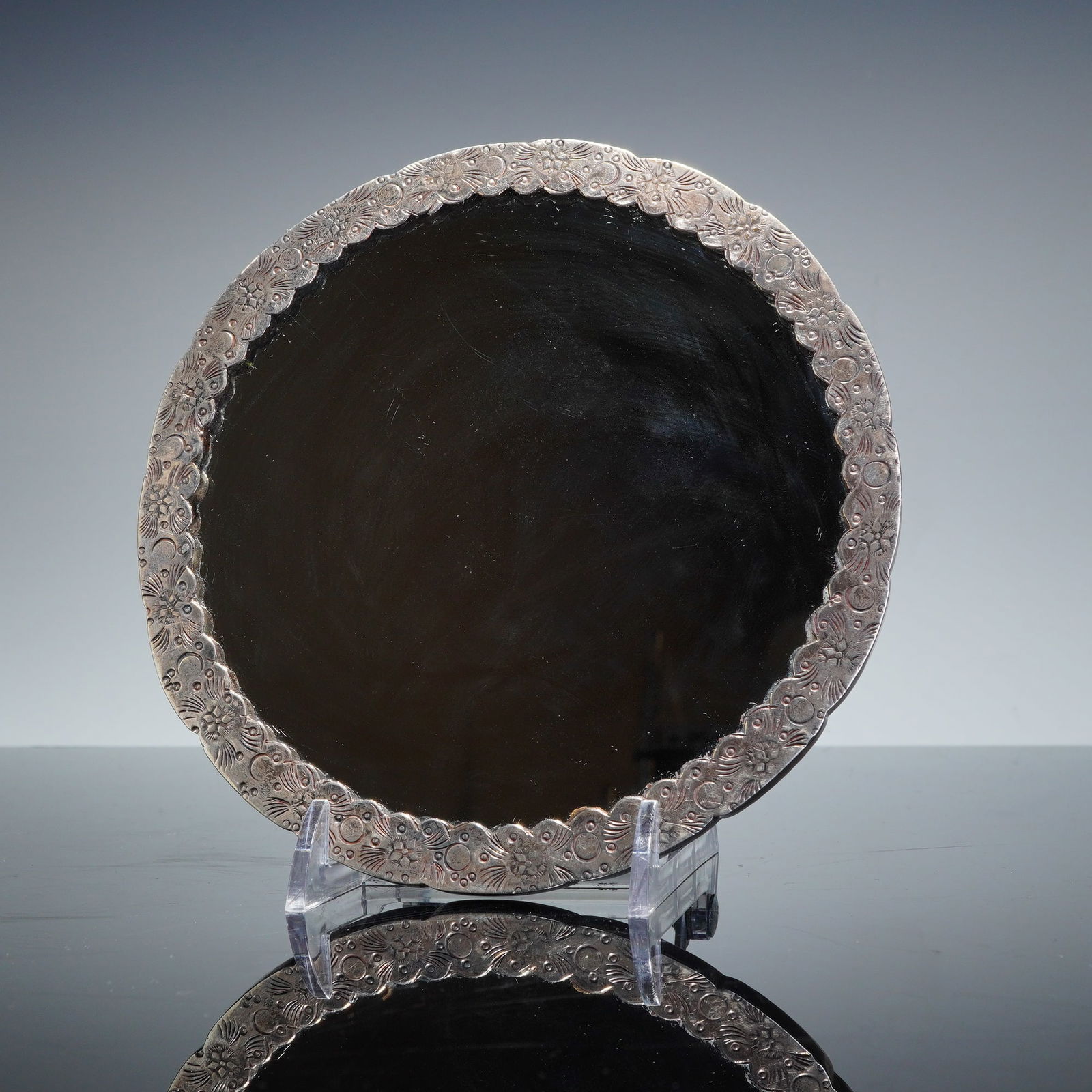 Egyptian .900 Silver Hand Mirror with Bird Handle: This Egyptian silver hand mirror is encased within a heavily ornamented silver mount. The obverse displays a scalloped border with embossed floral and scrollwork motifs. The reverse is elaborately dec