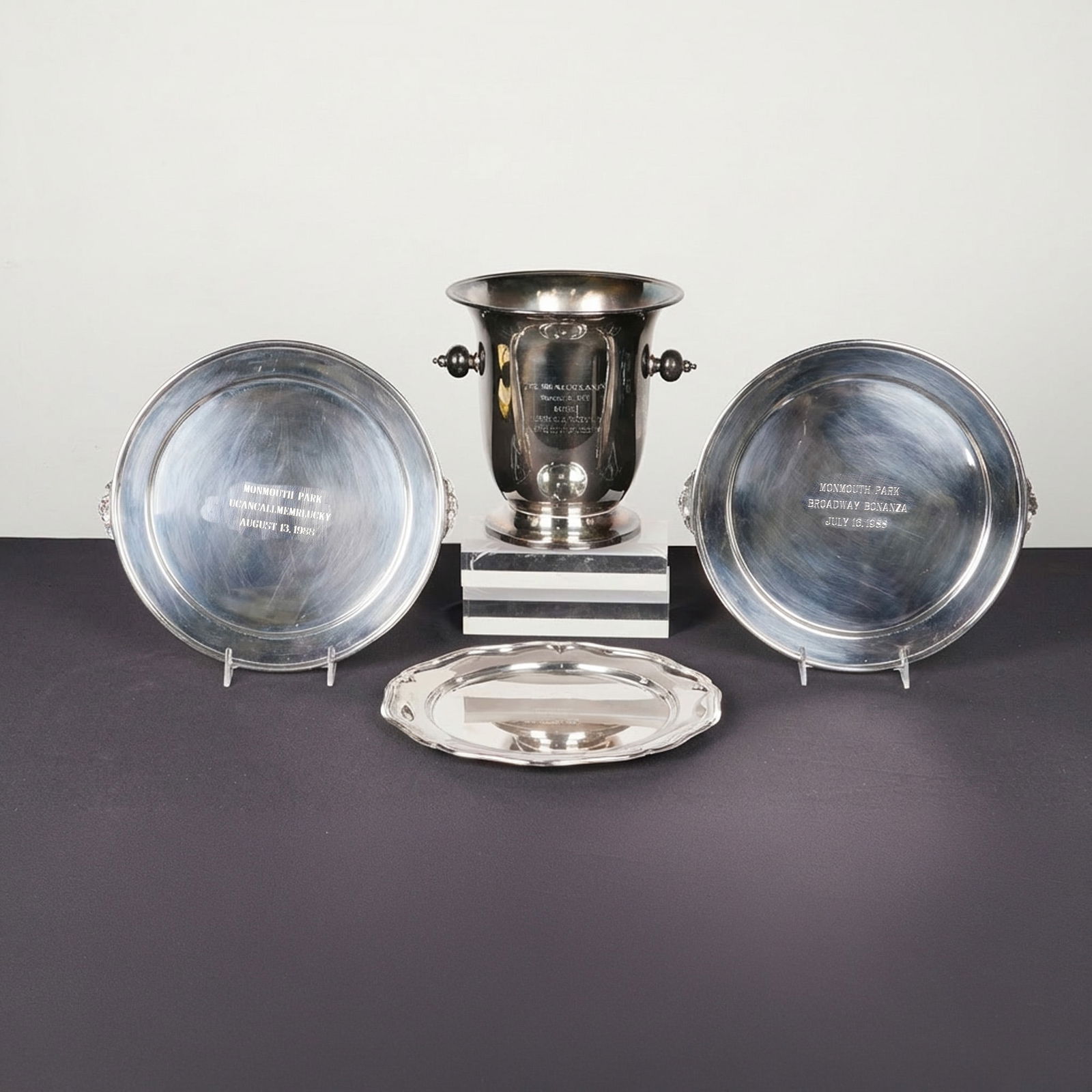 4pc Silver-Plated Horse Racing Trophy and Engraved Salvers: This collection consists of four silver-plated presentation items commemorating horse racing events from 1987 and 1988. The group includes one bucket-style trophy cup and three circular salvers. The t