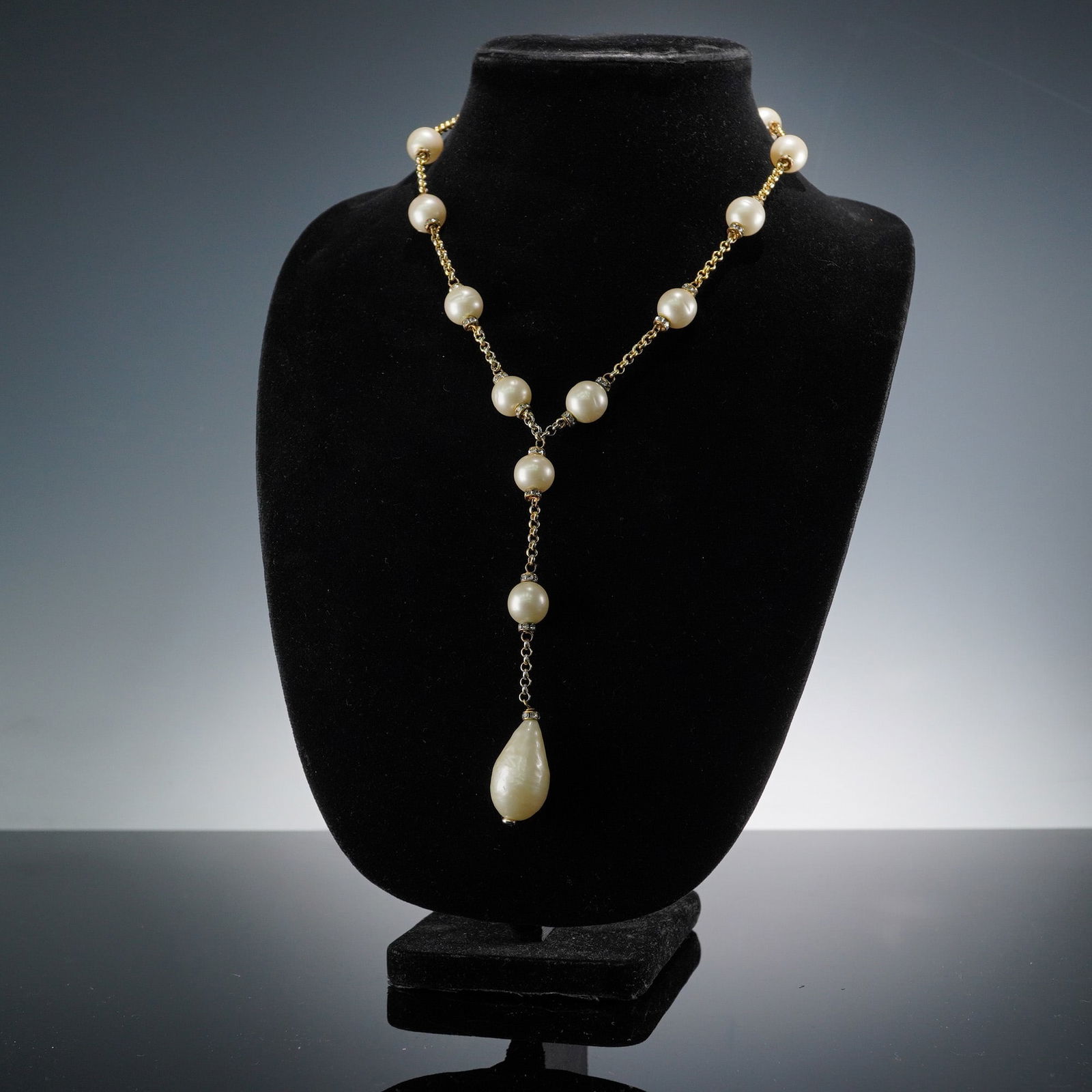 Chanel Faux Pearl & Gold-Tone Lariat Necklace with Teardrop: A CHANEL faux pearl and gold-tone lariat necklace, crafted from gold-toned metal. The chain is interspersed with eleven spherical simulated pearl beads, each accented with a bezel of small clear facet
