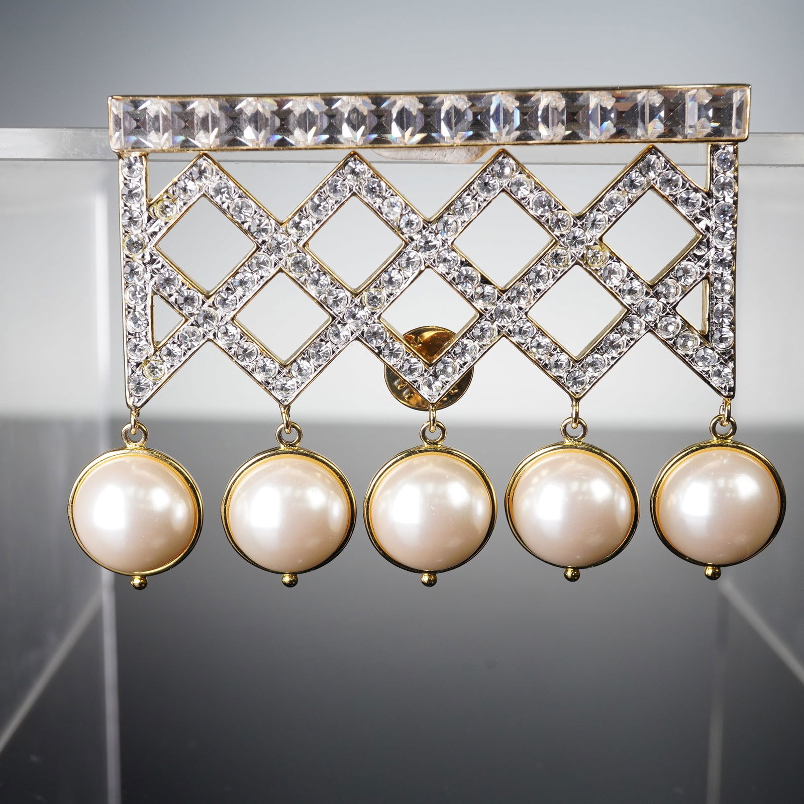Valentino Gold-Tone Faux Pearl and Rhinestone Dangle Brooch, Made in Italy: A Valentino gold-tone brooch, featuring a rectangular bar top set with baguette-cut clear rhinestones, suspending a diamond-lattice panel fully encrusted with smaller round-cut clear rhinestones. Five