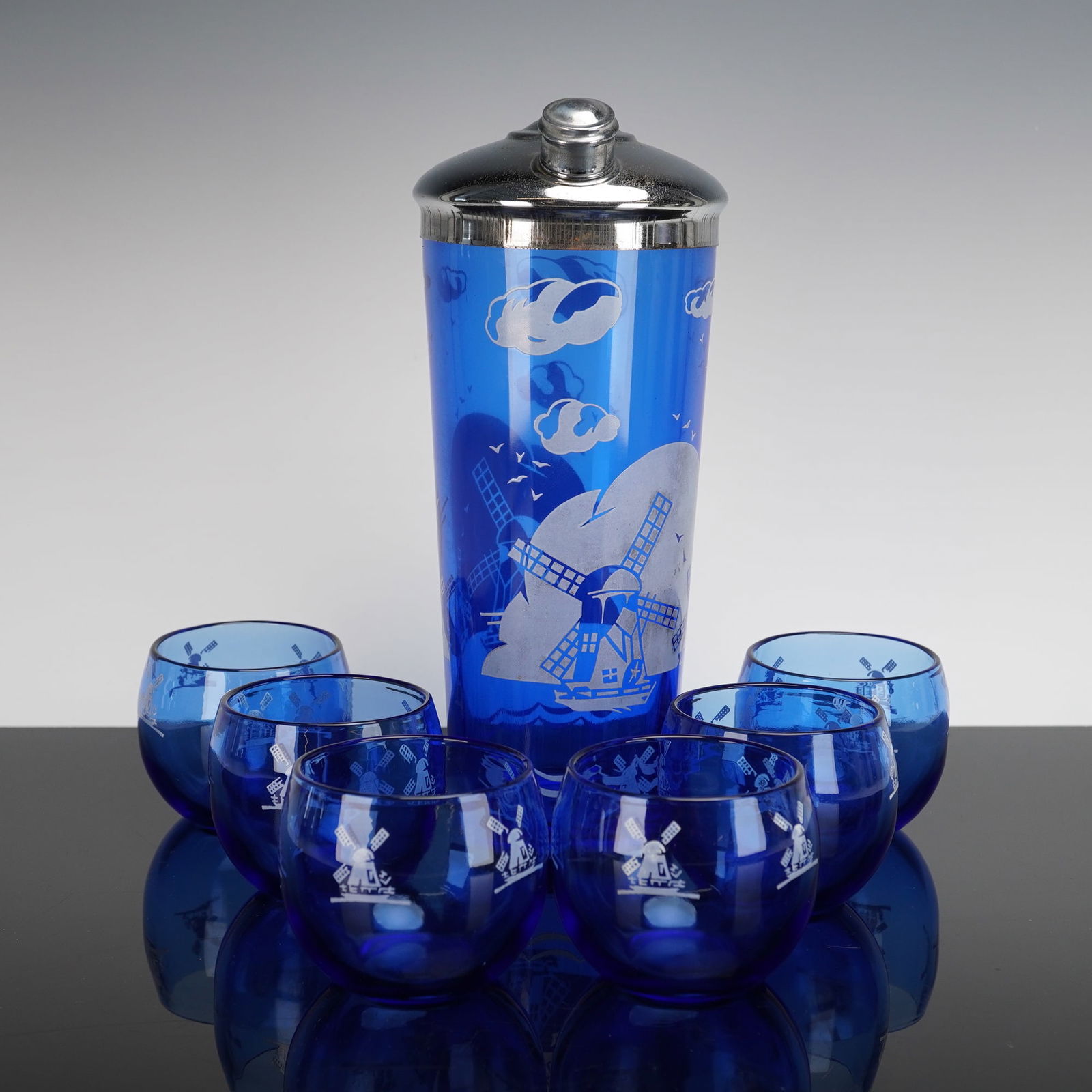 7pc Hazel Atlas Cobalt Blue Cocktail Shaker and Roly Poly Glasses Set: Cocktail set features a vibrant cobalt blue glass shaker accompanied by six matching "Roly Poly" tumblers, exemplifying classic mid-century barware design. Produced by the Hazel Atlas Glass Company, t
