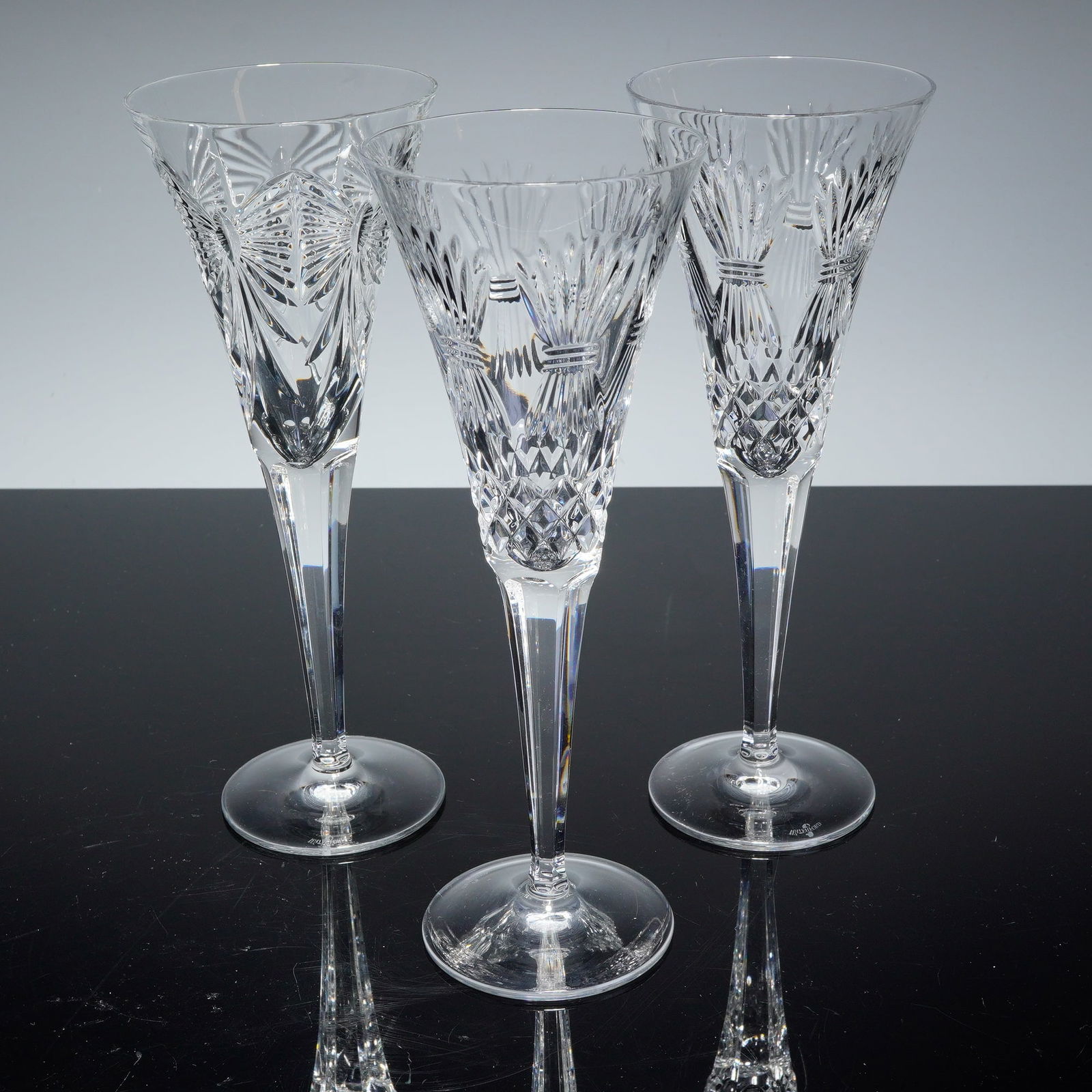 3pc Waterford Millennium Champagne Toasting Flutes, Prosperity & Happiness: Collection including two in the Prosperity pattern and one in the Happiness pattern. The Prosperity design is detailed with a wheat motif symbolizing abundance and success, while the Happiness pattern