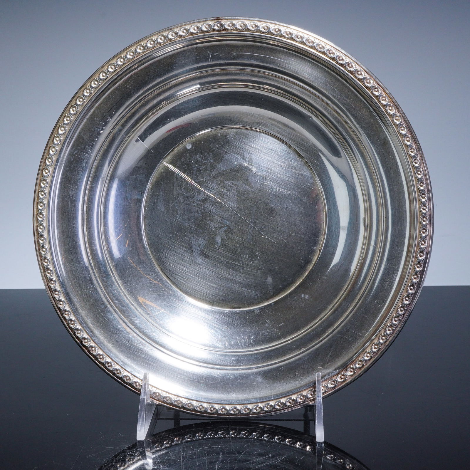 Rogers Sterling Silver Bowl with Flower Relief Rim Pattern 3050: A Rogers Sterling Silver serving bowl featuring a circular form with a wide rim. The decoration consists of a continuous repousse band in a flower relief rim pattern featuring rosettes and a beaded bo