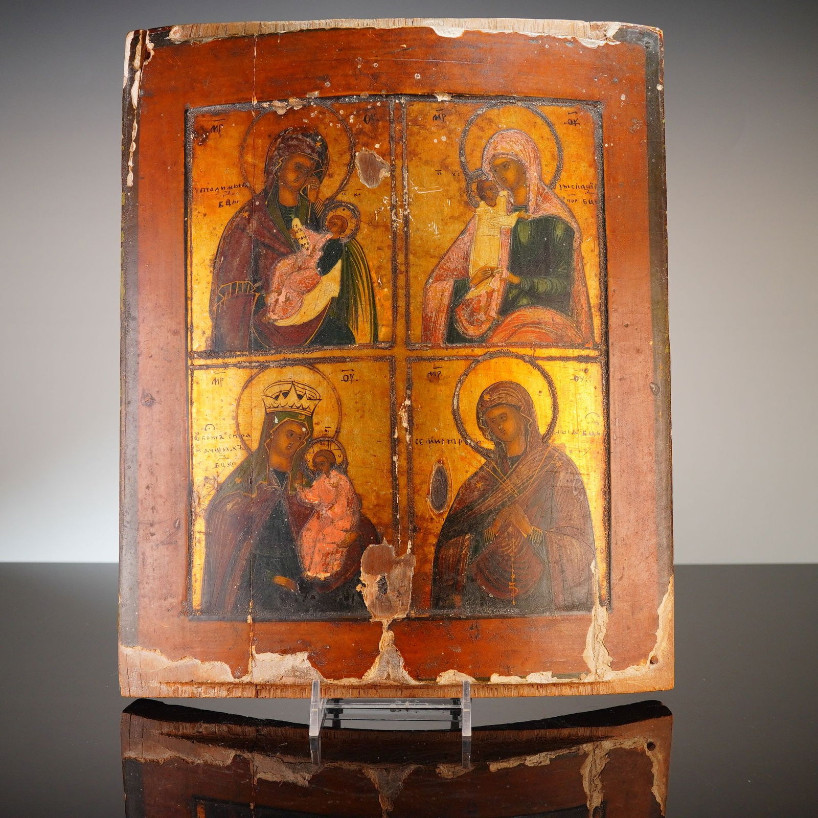 19th Century Russian Four-Part Icon of the Mother of God: This 19th-century Russian Orthodox icon is executed in tempera and gold leaf on a curved wooden panel. The composition is divided into four quadrants, each depicting a specific manifestation of the Vi