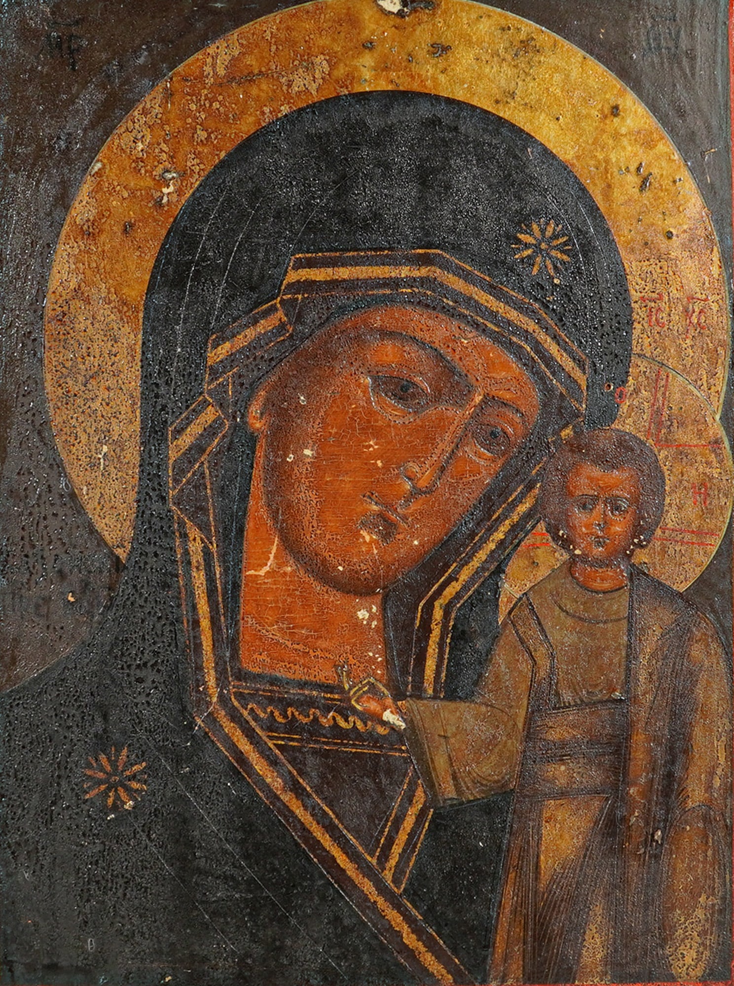 19th Century Russian Orthodox Icon of Our Lady of Kazan: This Russian Orthodox icon of Our Lady of Kazan (The Virgin and Child) is painted on a wooden panel. The work is executed in tempera and gilt on wood, depicting the Virgin Mary in a dark brown maphori