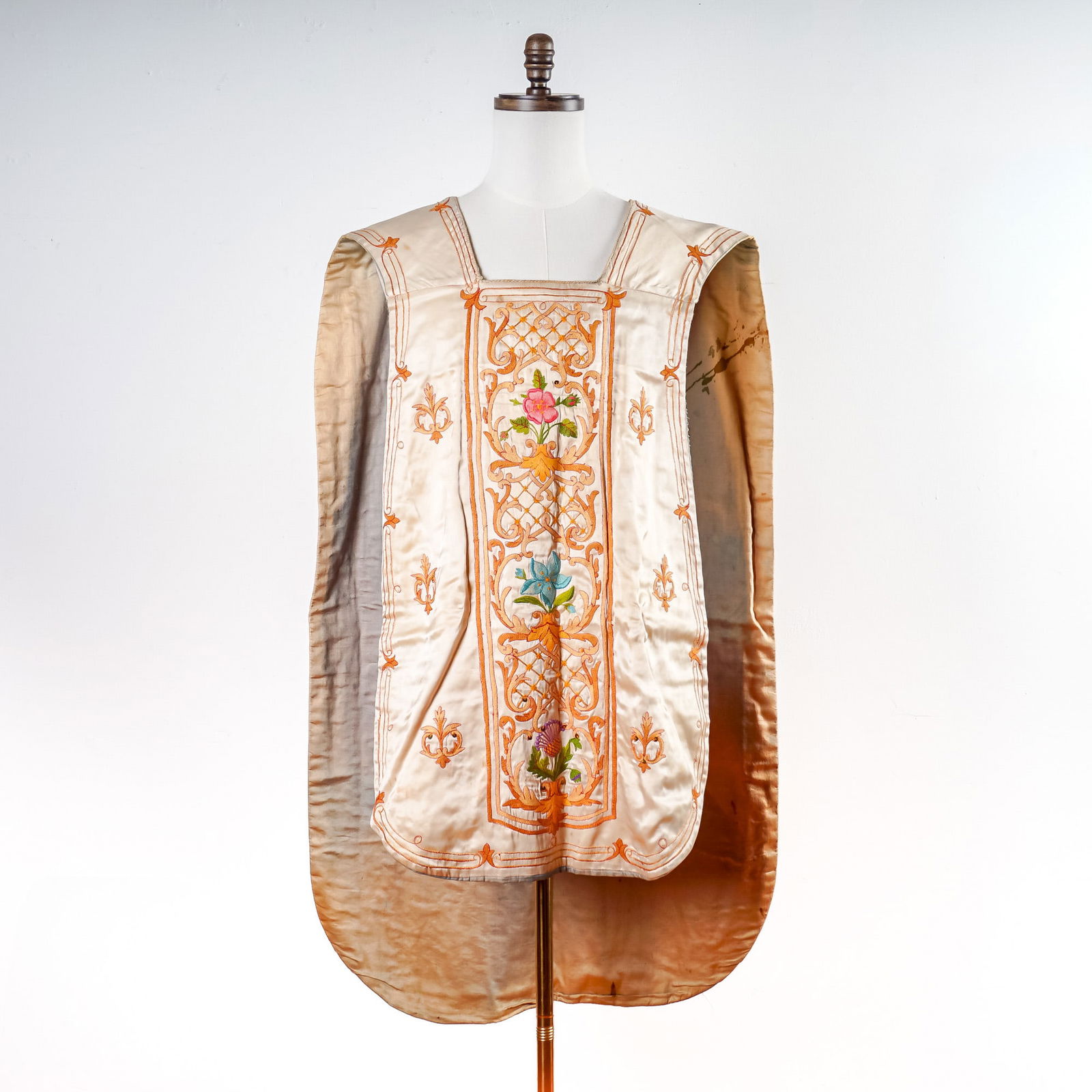 Early 20th Century Hand-Embroidered Silk Priest Vestment: Magnificent ecclesiastical chasuble finely crafted in silk and richly embroidered with colorful floral motifs and gilt threadwork. The front features a vertical panel of stylized blossoms framed by
