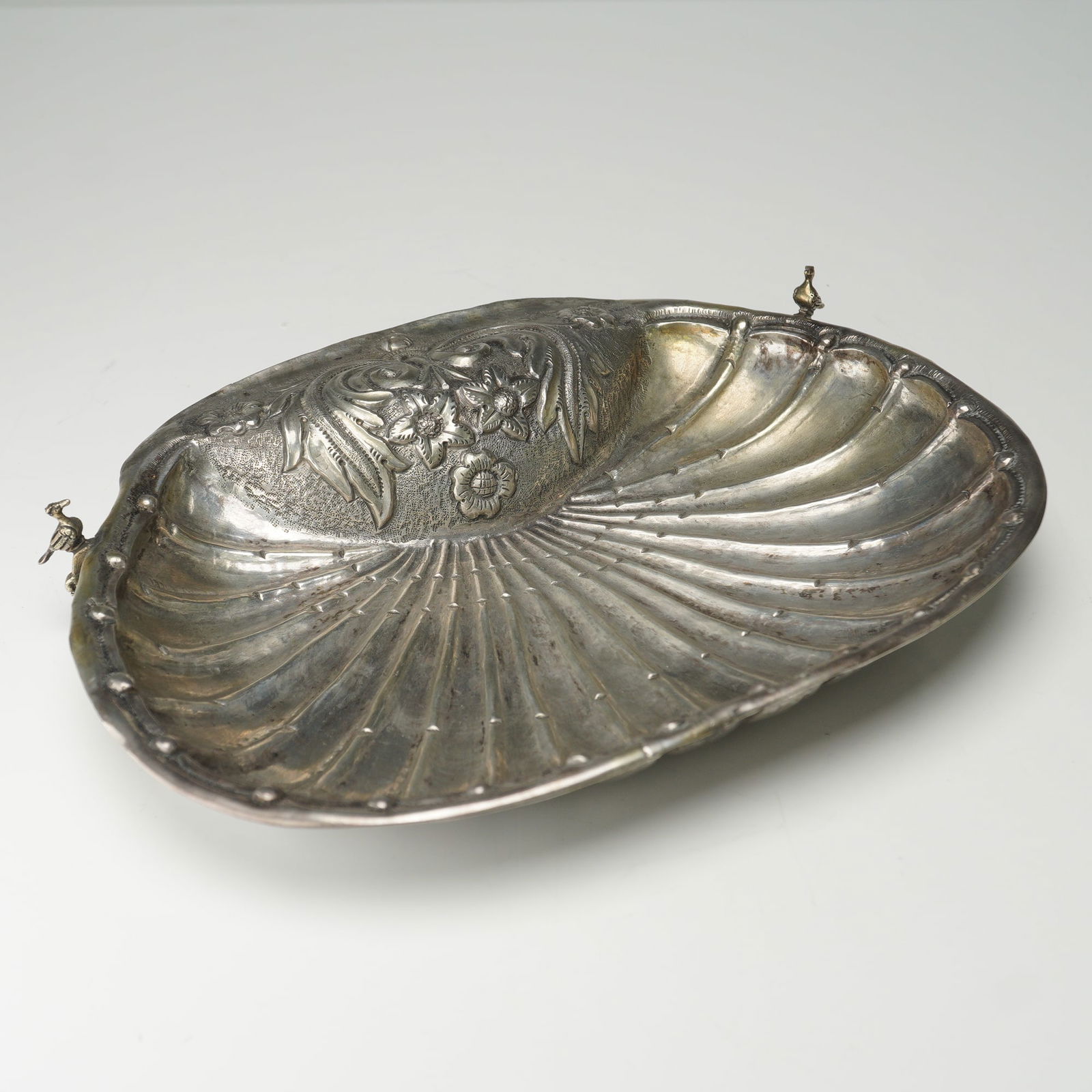 18th Century Spanish Colonial Silver Baptism Dish: An 18th century Spanish Colonial silver baptismal dish of scalloped shell form. The dish is formed with floral motifs, and stylized foliate elements, finished with shell patterning to interior.