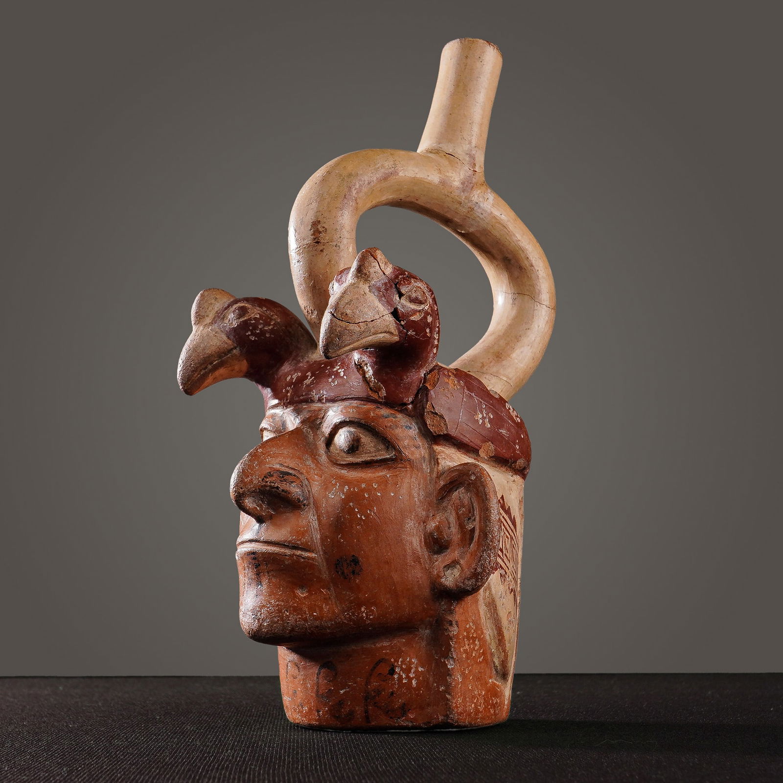 Pre-Columbian Moche IV Ceramic Portrait Vessel w/ Bird Head Effigies: A Pre-Columbian Moche IV (circa 500-800 AD) polychrome ceramic portrait vessel from Peru. This anthropomorphic vessel depicts a male face with prominent features and small, dark decorative markings on