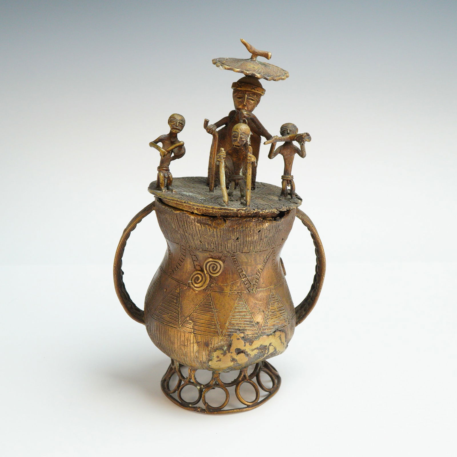 Asante Kuduo Bronze Lidded Vessel: This Asante Kuduo bronze lidded vessel is a cast copper alloy container from Ghana, West Africa. Created using the lost-wax casting method, the vessel features a bulbous body decorated with incised ge