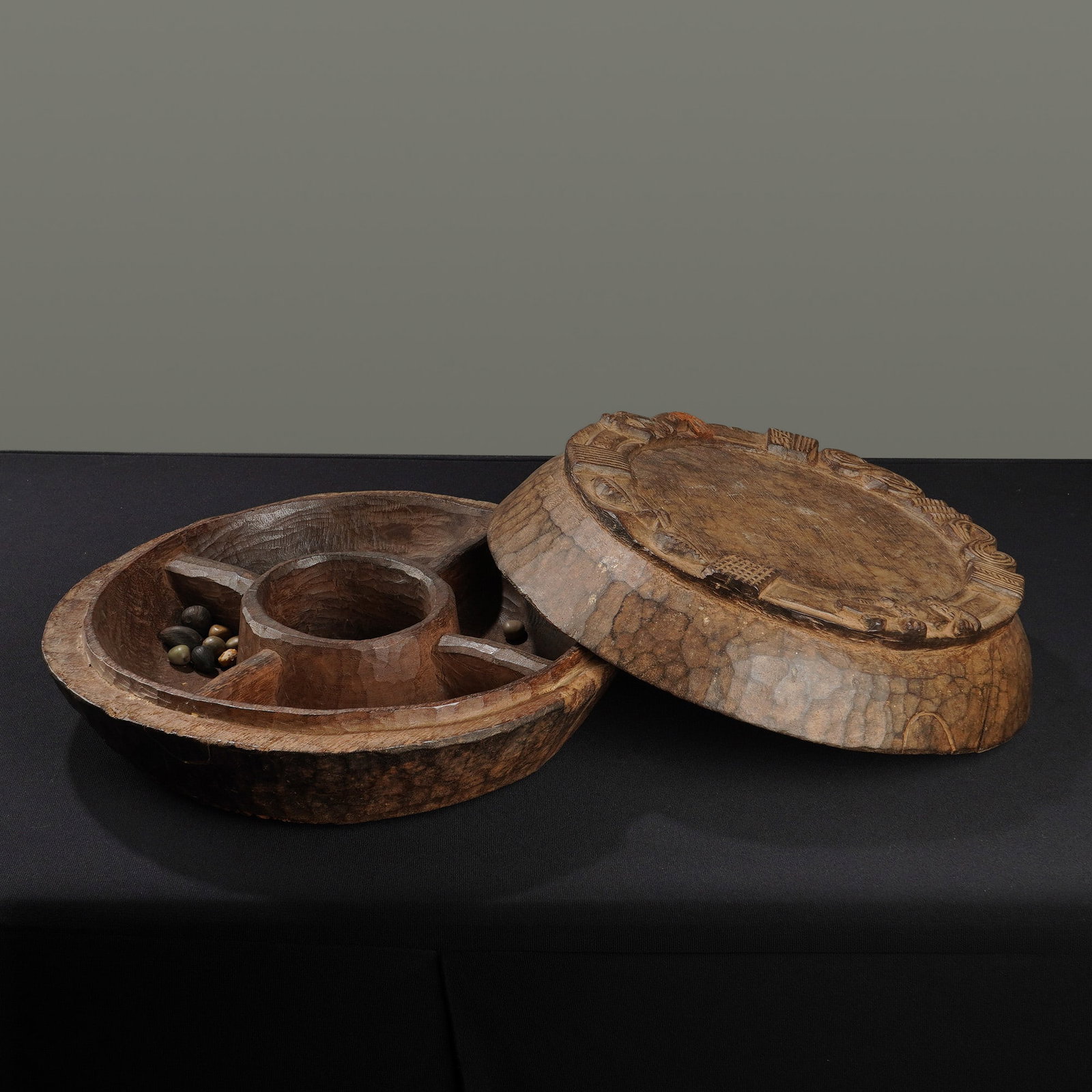 Yoruba Opon Igede Ifa Divination Box: This hand-carved wood Yoruba Opon Ifa is a lidded divinization tray used by diviners to seek answers from the god of wisdom, Orunmila. The piece is constructed from a single block of wood and features