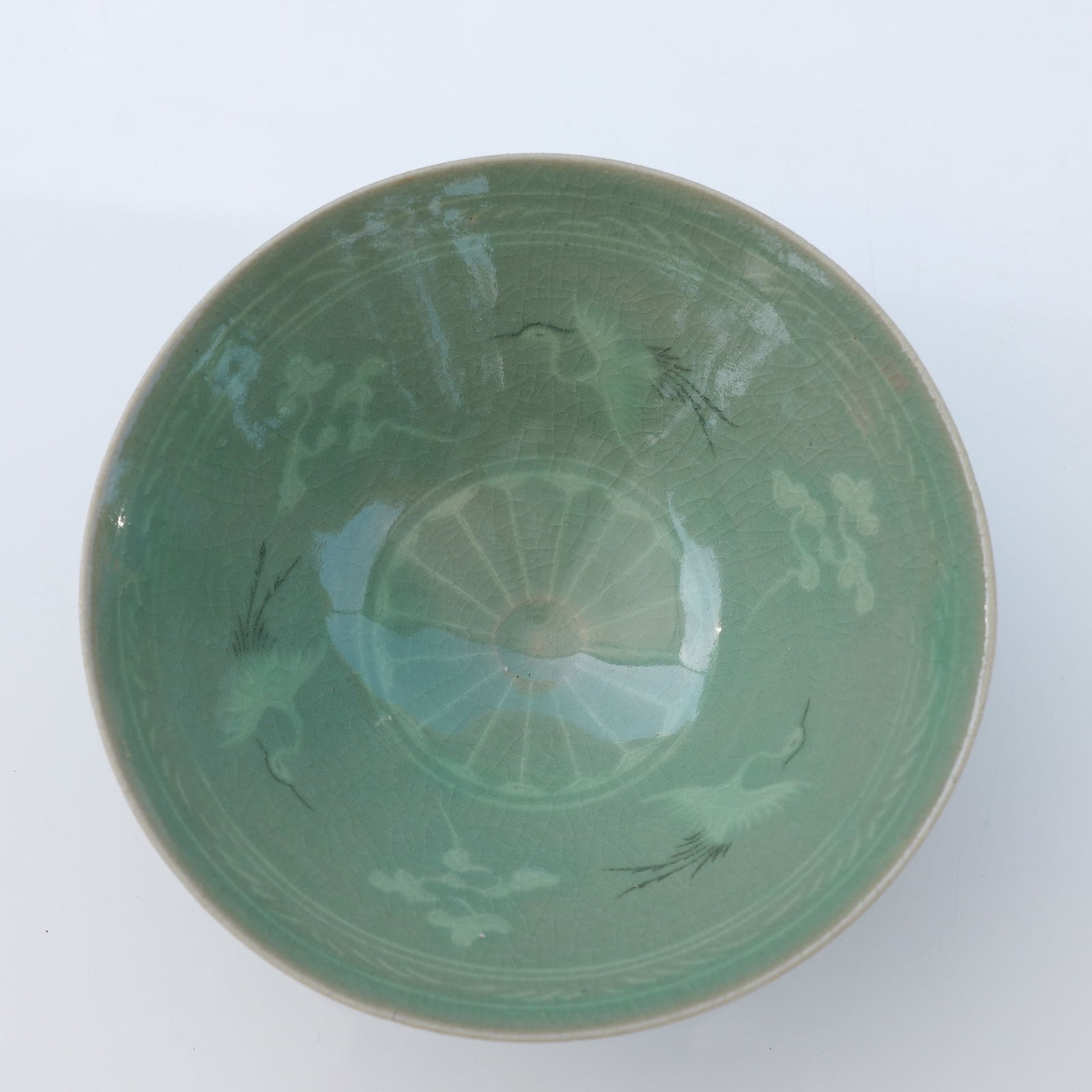Korean Celadon Ware Ceramic Crane Bowl: A celadon bowl featuring an inlaid design of cranes in flight, spaced around the inner surface. Finished in a celadon glaze with a pale green tone, the bowl showcases traditional inlay techniques with
