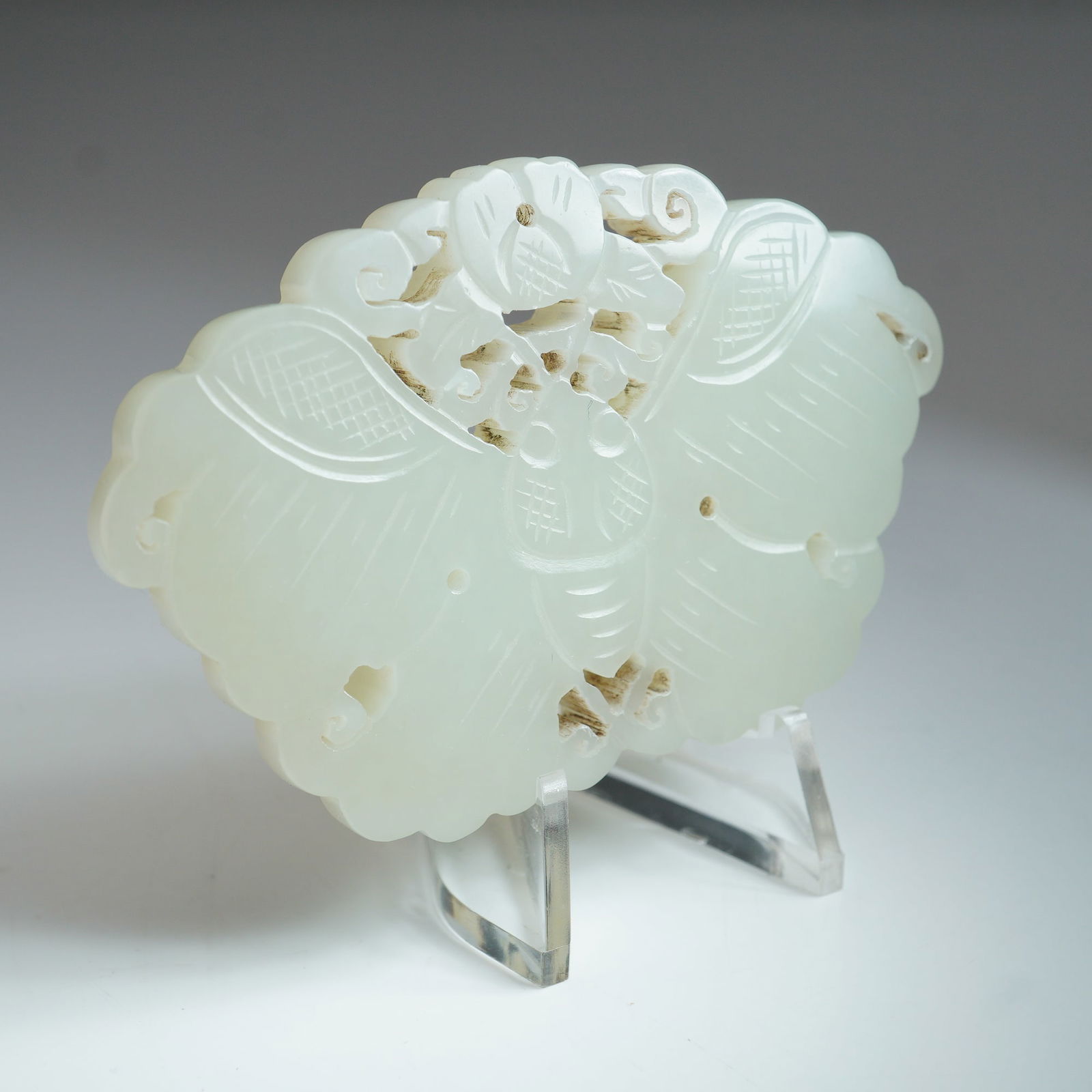 Chinese White Nephrite Jade Butterfly Plaque: Intricately carved in the form of a butterfly, featuring delicate openwork details and fine linear engravings across the wings and body. The piece exhibits soft translucency characteristic of jade, wi