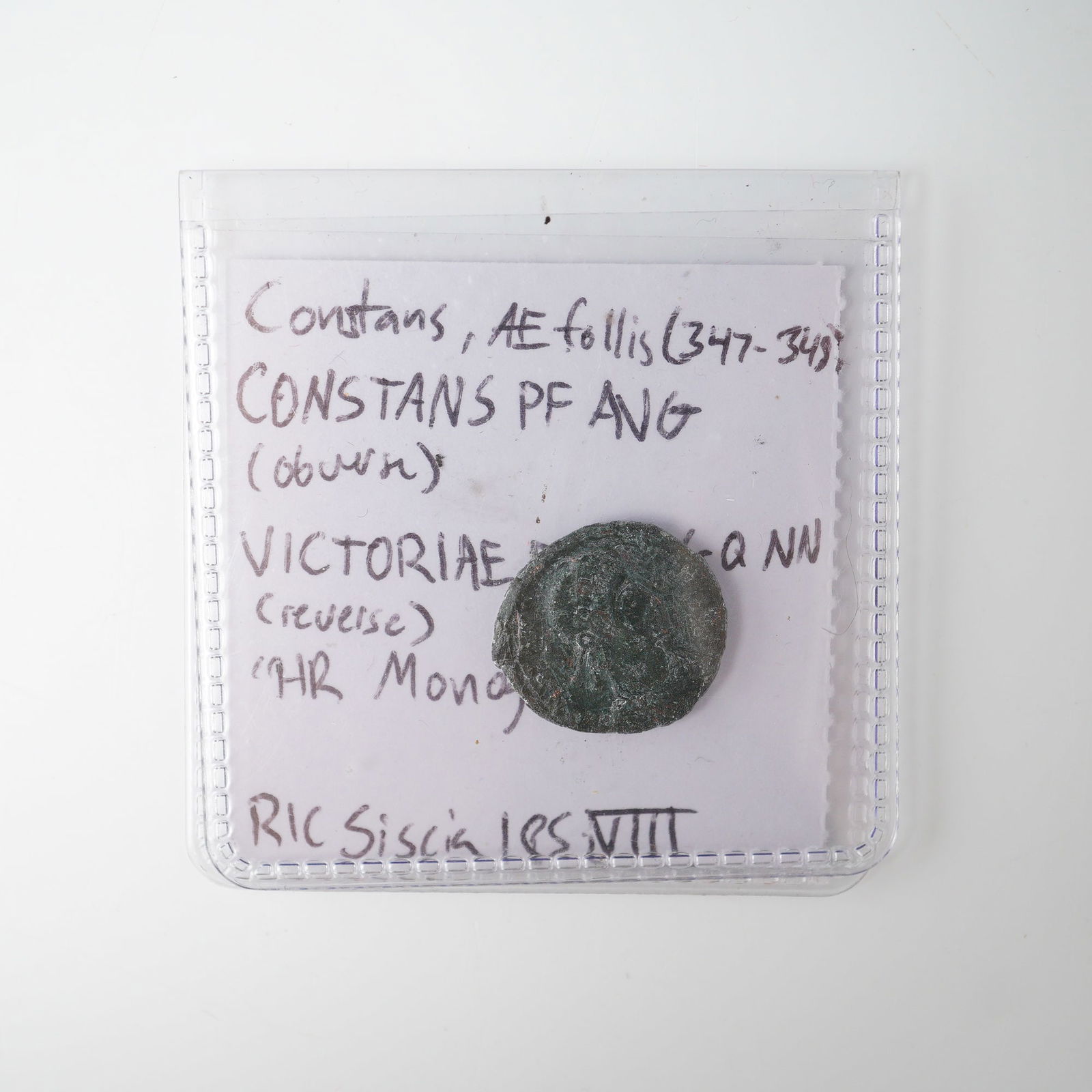 Ancient Constans AE Follis: The obverse bears the inscription CONSTANS PF AVG, featuring a laureate, draped, and cuirassed bust of Constans facing right. The reverse depicts two Victories standing, holding between them a wreath
