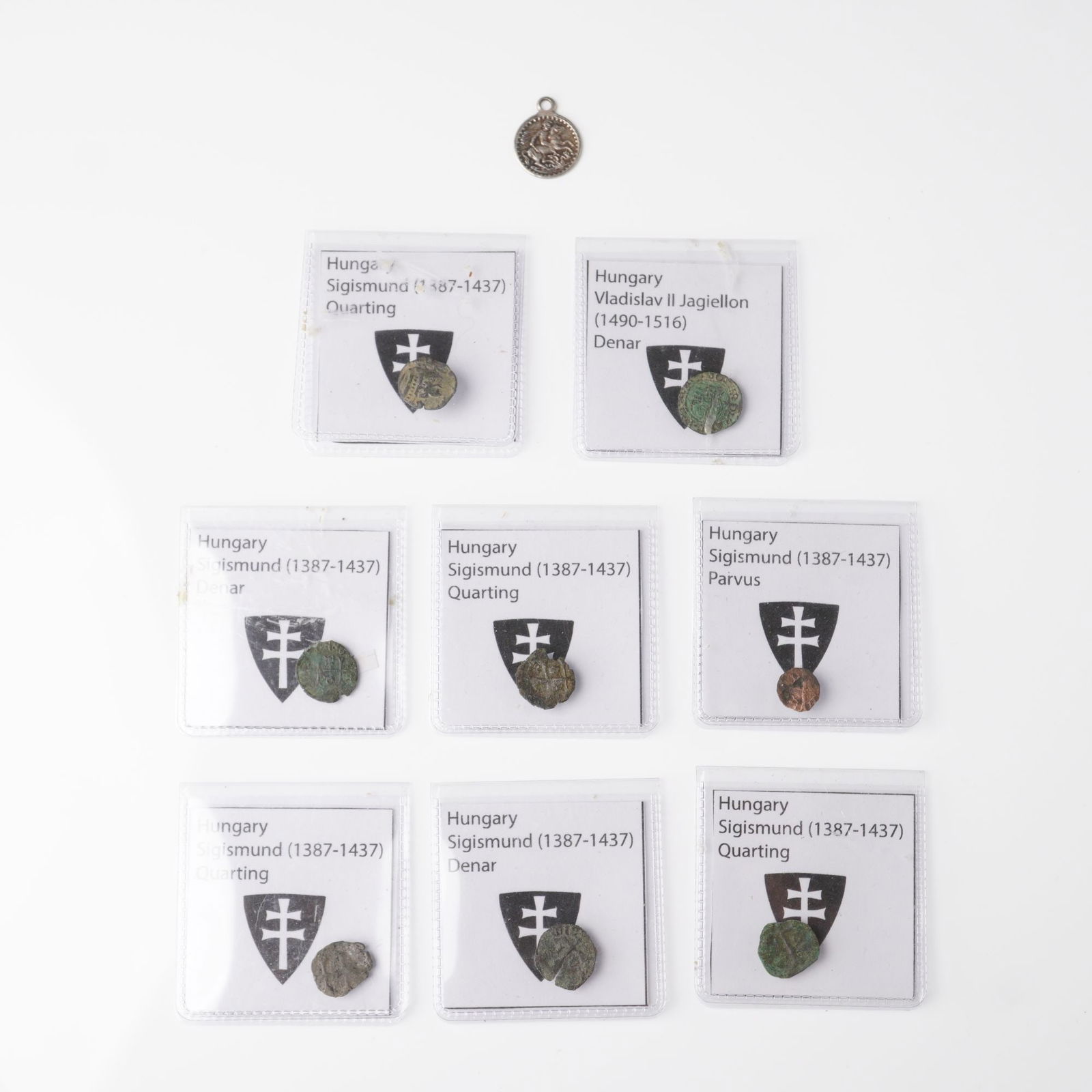 9pc Group of Medieval Hungarian Coins & British Pendant, 14th-16th century: A collection of eight medieval Hungarian silver and billon coins accompanied by one early British pendant. The group includes two Denars, one Parvus, and four Quartings issued under King Sigismund of