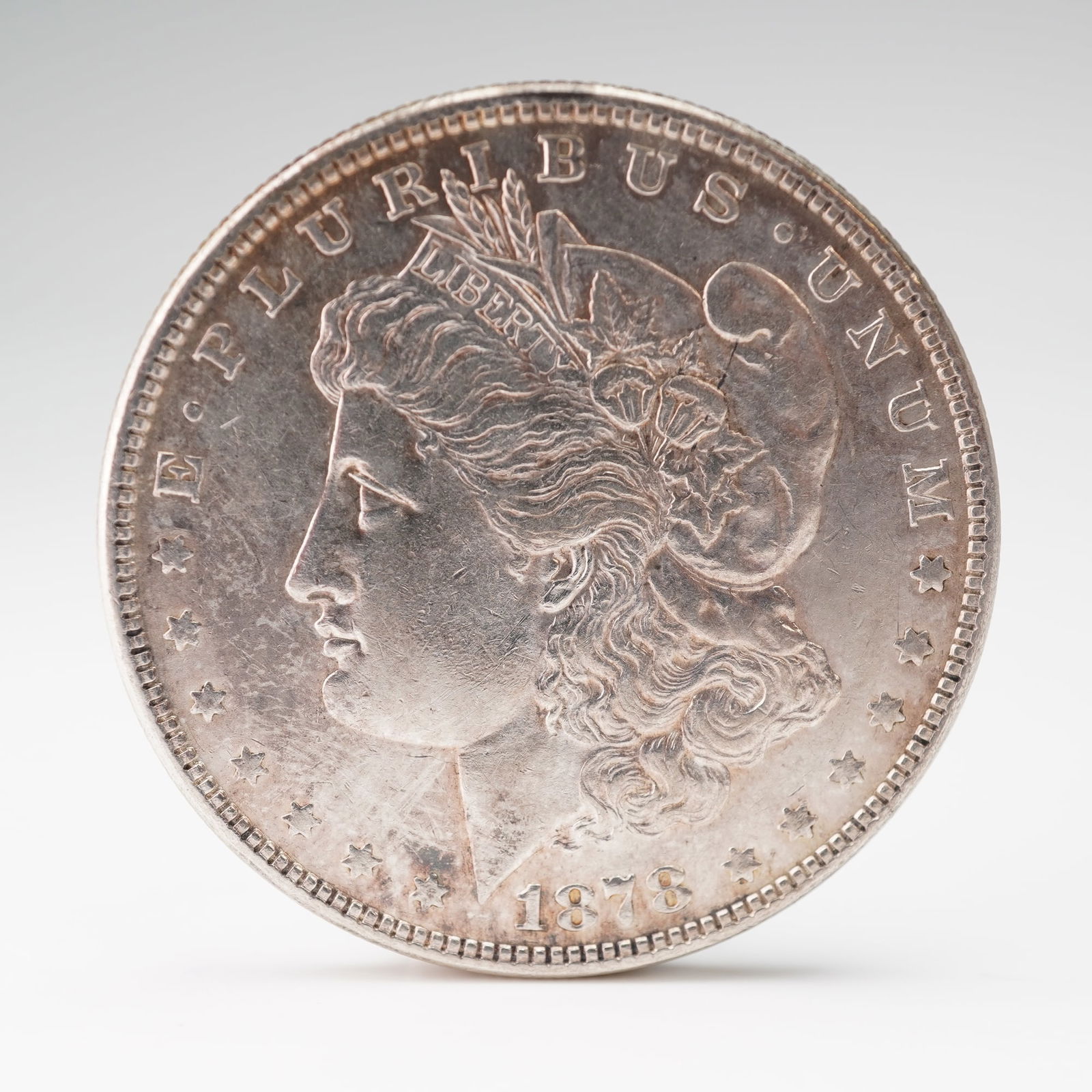 1892 Morgan Silver Dollar: Featuring the profile of Lady Liberty on the obverse wearing a Phrygian cap adorned with wheat and cotton, symbolic of American agriculture, with the inscriptions E PLURIBUS UNUM and LIBERTY. The reve