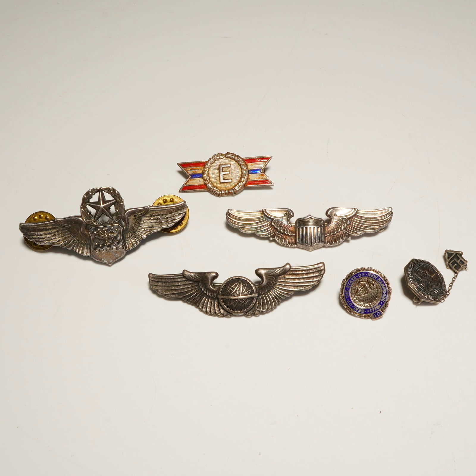 6pc Sterling Silver US Army and Civilian Pins and Badges: A six-piece collection of mid-20th-century military and civilian pins, composed of sterling silver with enamel accents. The group includes three U.S. military-style winged badges: a Command Pilot wing