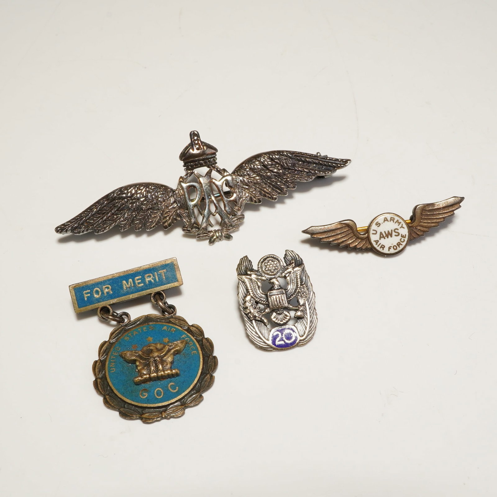 4pc Sterling U.S. Army Badges and British RAF Wings Brooch: This lot consists of three U.S. Army badges and pins and one British Royal Air Force (RAF) wings brooch. The collection features a RAF sweetheart brooch with a King's Crown and central monogram. U.S.
