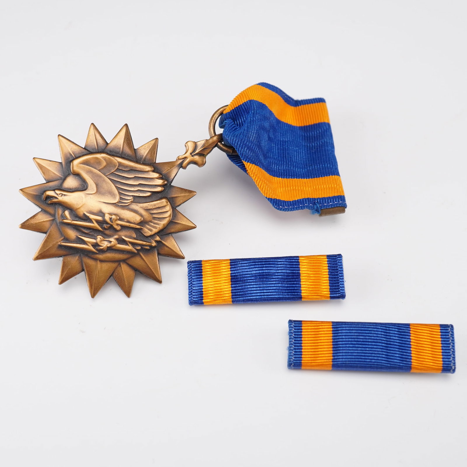 U.S. Army Air Medal with Ribbon Bars: United States Army Air Medal, awarded for meritorious achievement while participating in aerial flight. The bronze medallion features a high-relief American eagle in flight over stylized lightning bol