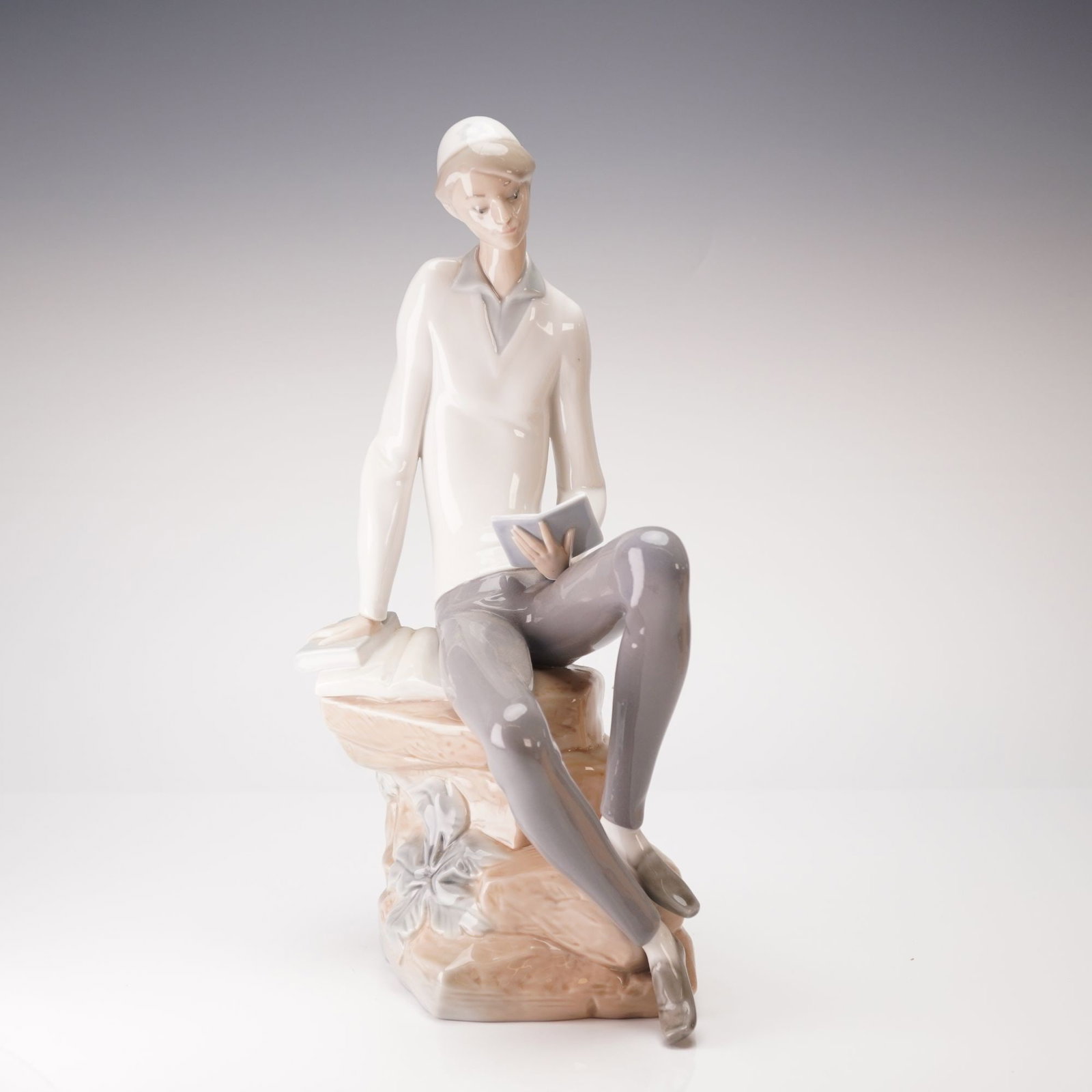 Lladro Figurine, Hebrew Student 1004684: This is a fine Lladro porcelain figurine titled The Scholar, model number 1004684, also known as the Hebrew Student. The piece depicts a young man in a pensive, studious pose, seated on a textured