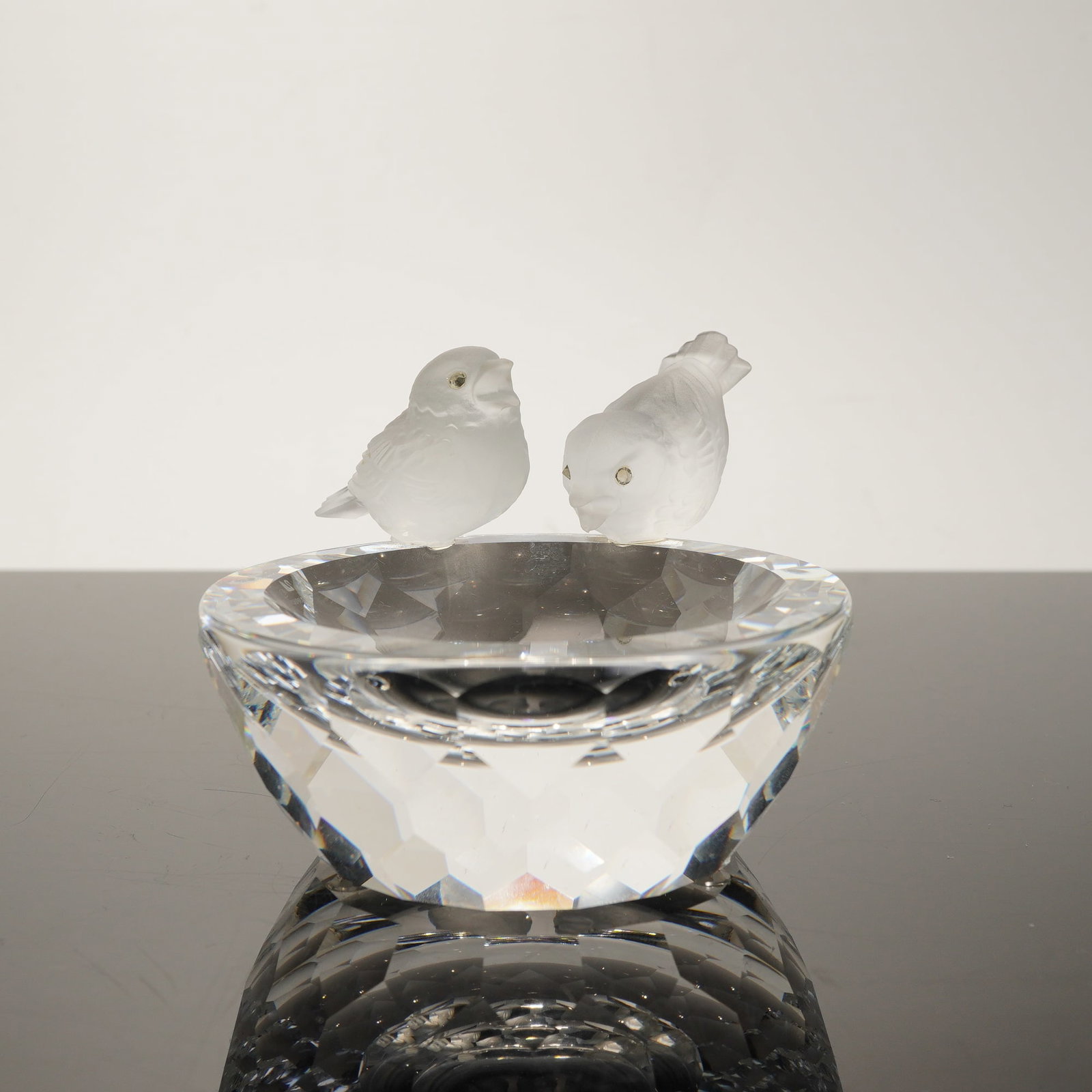 Swarovski Silver Crystal Bird Bath Figurine, Model 7460: This Swarovski Silver Crystal figurine, model number 7460, features two songbirds perched on a birdbath. The design includes a clear lead crystal bowl with numerous triangular facets and two frosted c