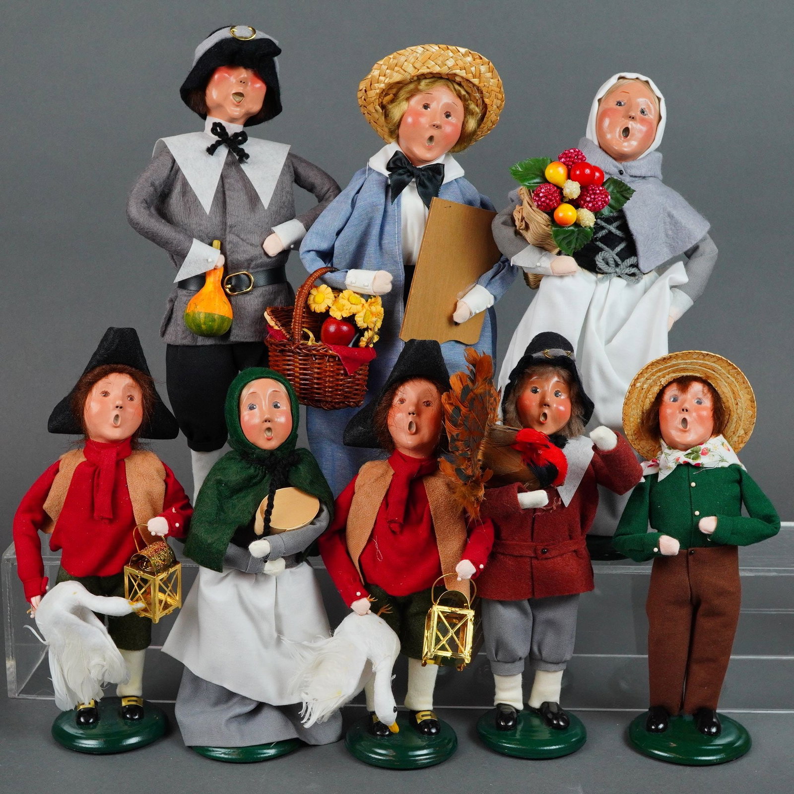 Collection of Eight Byers Choice Ltd The Carolers Dolls, Autumn Theme: Handcrafted figurines include figures dressed in colonial and pilgrim style attire made from various textiles such as felt and cotton. Each figurine features a hand painted face and stands on a signat