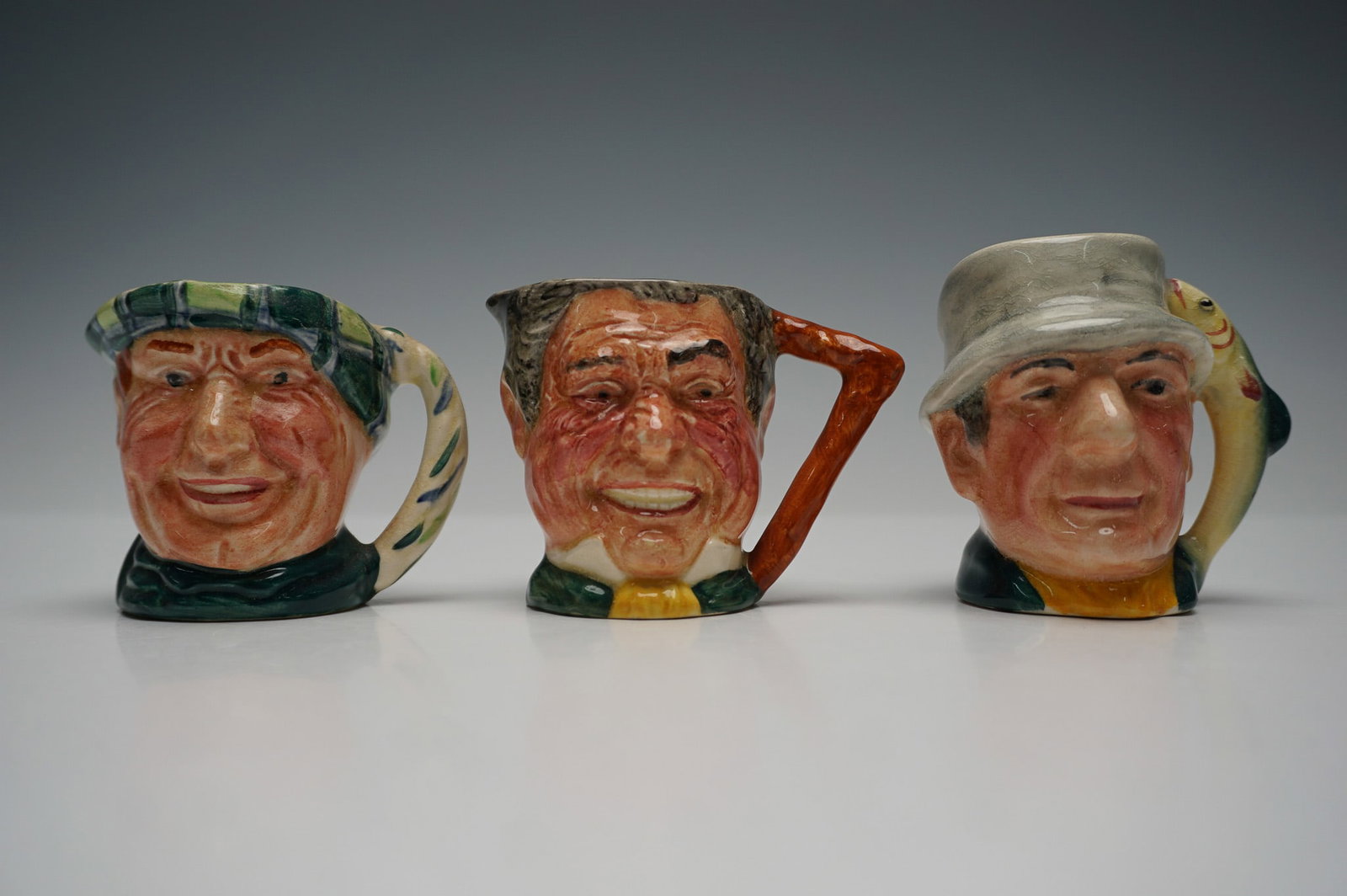 3pc Lancaster Sandland Character Jugs: Charming set of three hand-painted character toby jugs by Sandland, Lancaster, made in Staffordshire, England. Each mug showcases expressive detailing and vibrant colors, depicting notable character