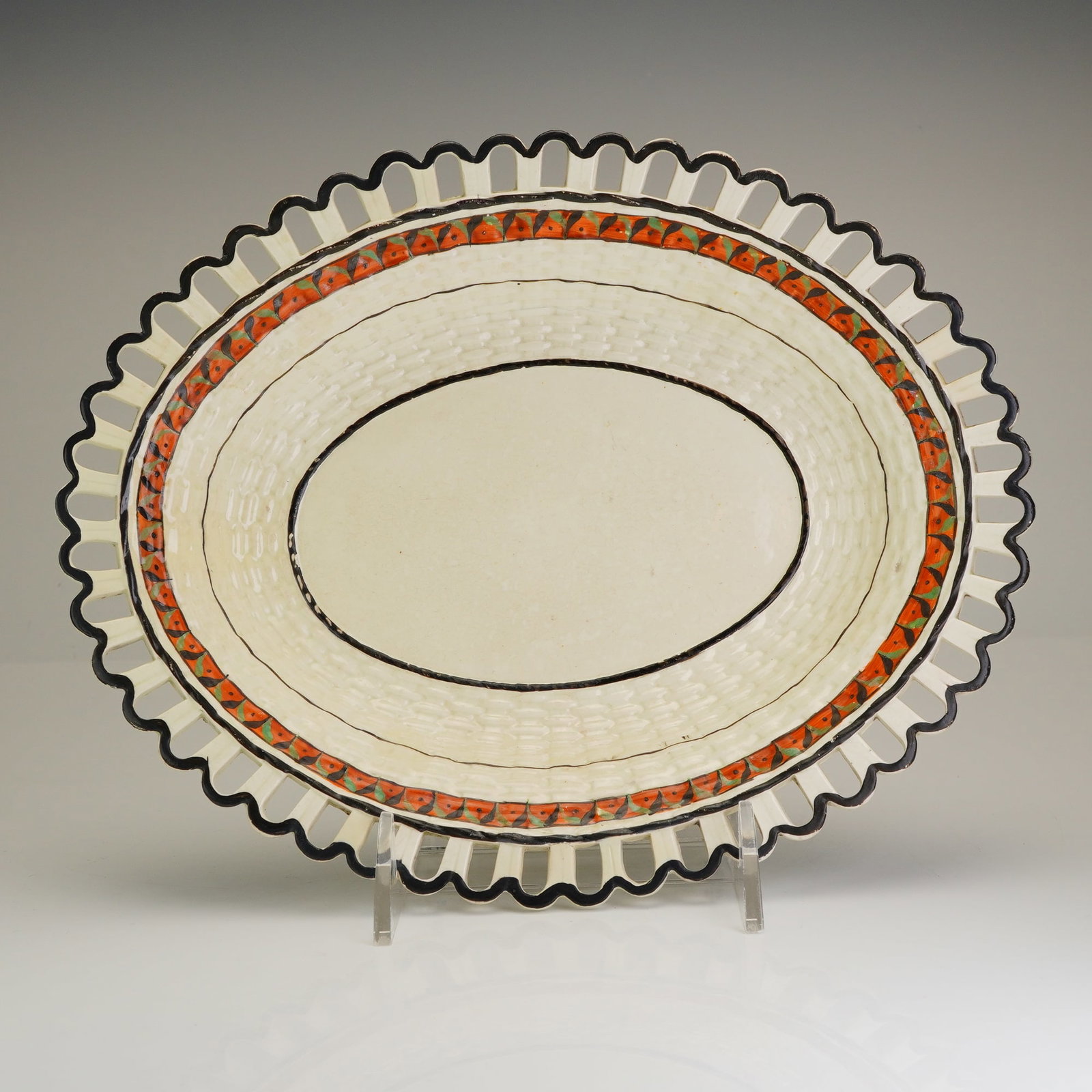 Neale & Bailey Woven-textured ceramic bowl with pierced rim: This late 18th-century English creamware oval basket is a product of the Staffordshire partnership of James Neale and John Bailey, active circa 1786-1790. The earthenware piece is a woven-textured cer