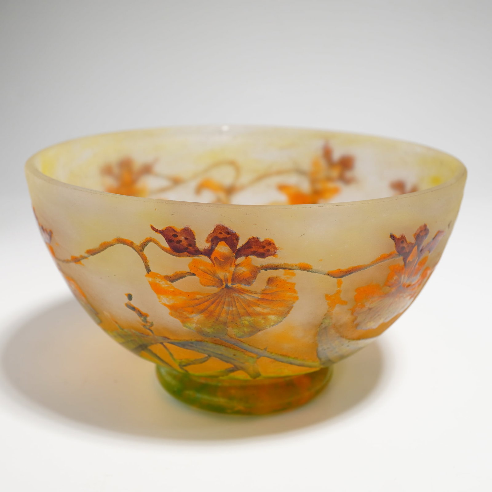 Daum France Art Nouveau Cameo Glass and Enameled Orchid Bowl: This exquisite Art Nouveau footed bowl, or coupe, is a premier example of the organic School of Nancy aesthetic produced by Daum Freres. The vessel is crafted from multi-layered cameo glass,
