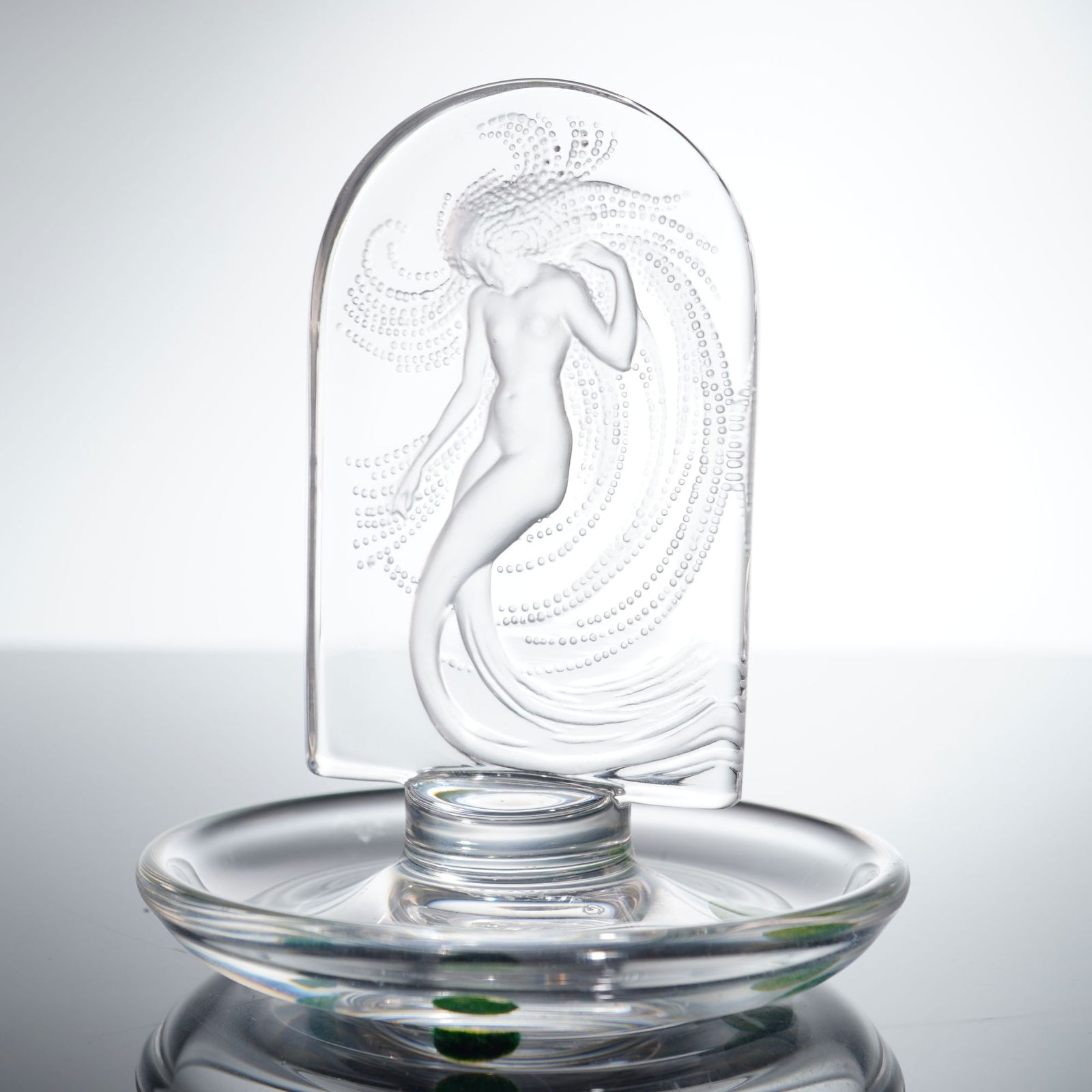 Lalique Frosted and Polished Crystal Naiade Ring Dish: A fine lead crystal "Naiade" ring dish or pin tray by Lalique, France. This piece features a central arch-topped plaque in high relief, depicting a graceful water nymph surrounded by rhythmic, cascadi