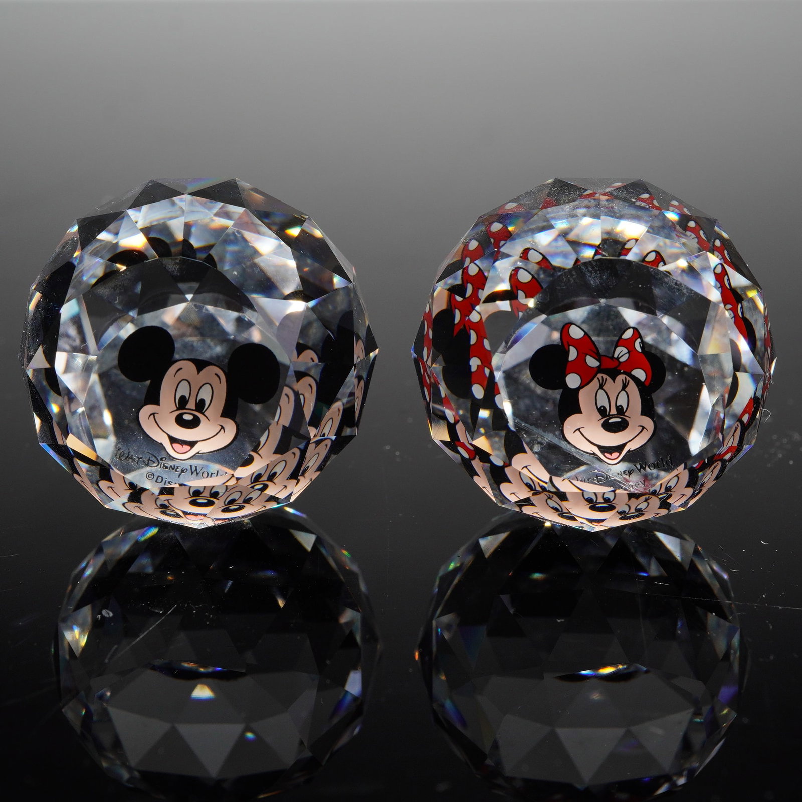 Arribas Brothers Disney Mickey and Minnie Swarovski Crystal Paperweights: A pair of contemporary faceted Swarovski crystal paperweights produced for Arribas Brothers and sold at Walt Disney World. This set includes one Mickey Mouse and one Minnie Mouse sphere. Each crystal