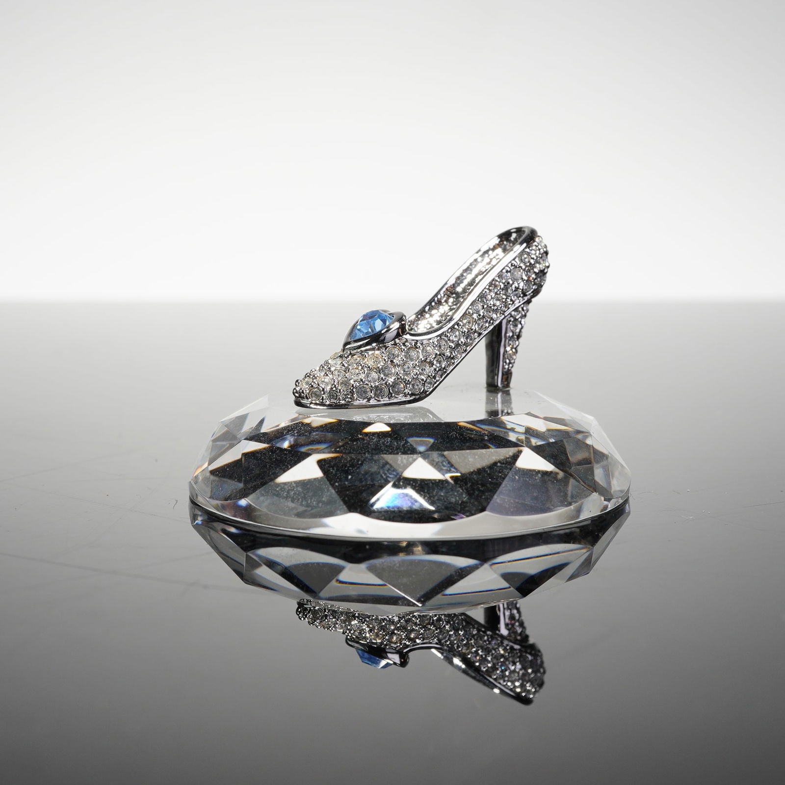 Arribas Brothers Disney Cinderella's Glass Slipper Figurine: This Arribas Brothers Disney Swarovski Crystal Cinderella's Slipper is a miniature collectible figurine produced for Disney Parks. The piece features a silver-toned high-heeled shoe encrusted with cle