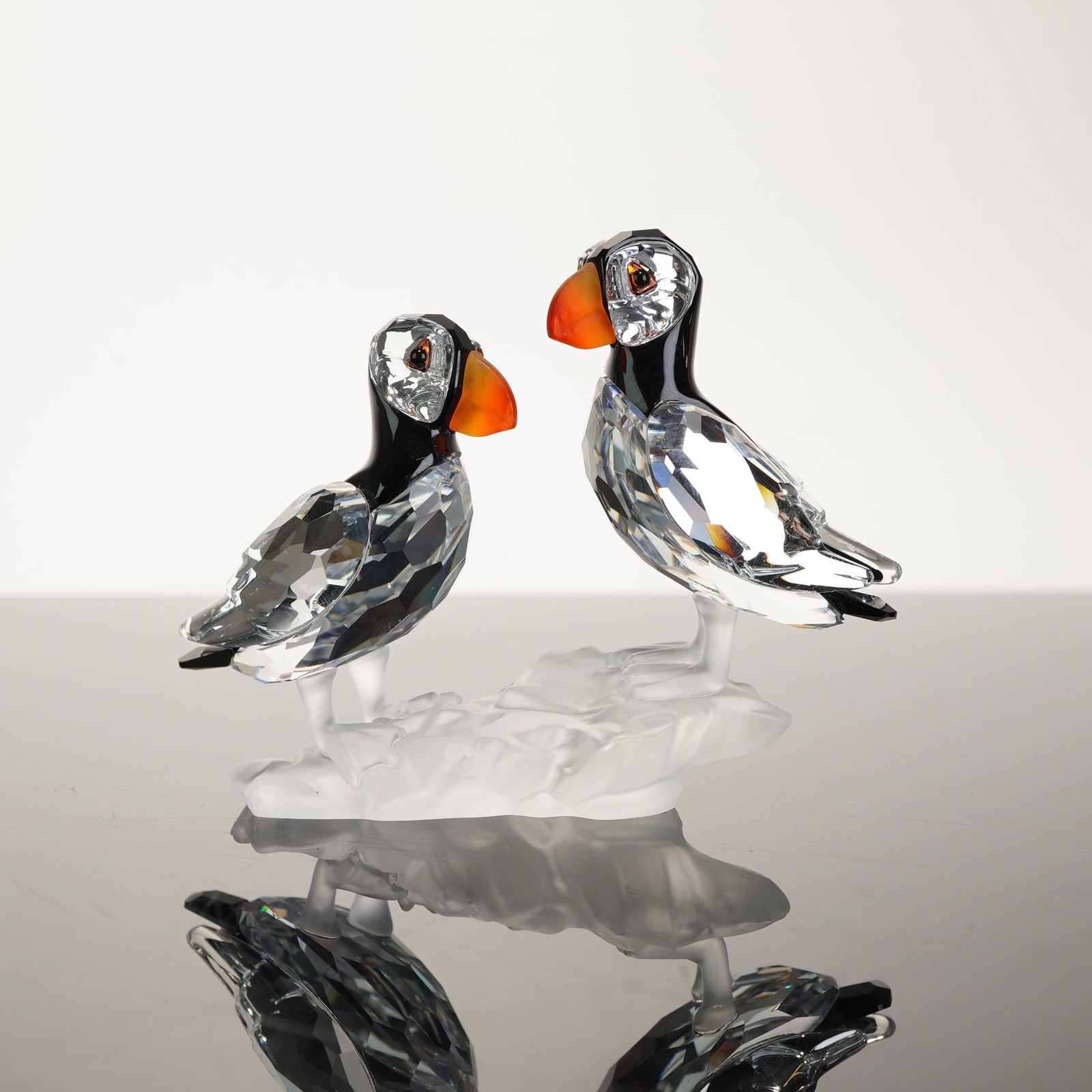 Swarovski A Pair of Puffins Figurine Model 261643: This Swarovski Silver Crystal figurine depicts a pair of Atlantic Puffins, model number 261643. Designed by Martin Zendron for the Among Flowers and Foliage collection, the piece features two birds pe