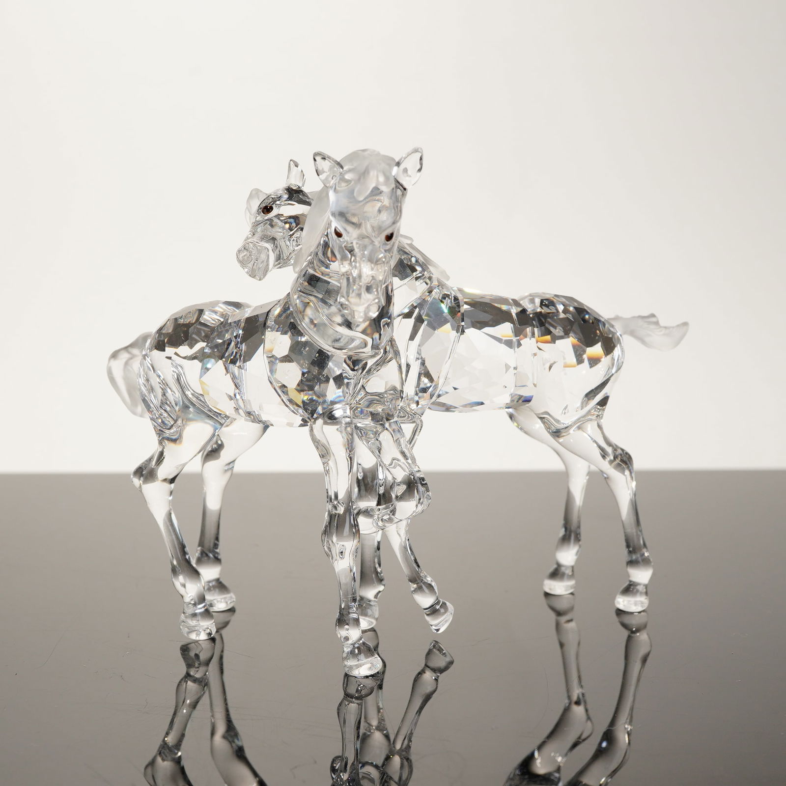 Swarovski Crystal Foals Figurine: This professional auction listing features a retired Swarovski crystal figurine titled "Foals" (Model 627637), originally part of the "Meadow & Blossoms" collection. The piece depicts two clear foals