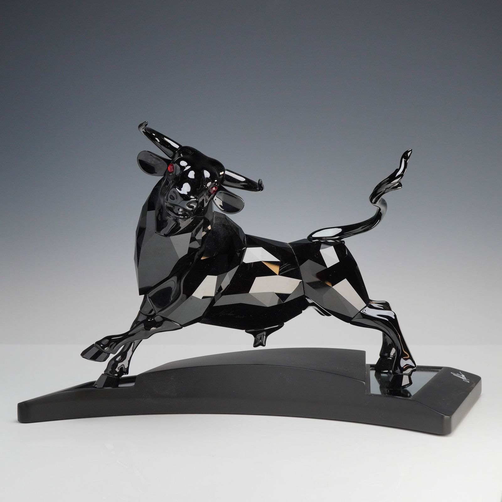 Swarovski Crystal Signed Numbered Limited Edition Figurine Black Bull 66034: Swarovski, model 660034, The Black Bull (Der Schwarze Stier). This limited edition sculpture depicts a powerful charging bull expertly crafted from full-cut black crystal with striking red crystal eye