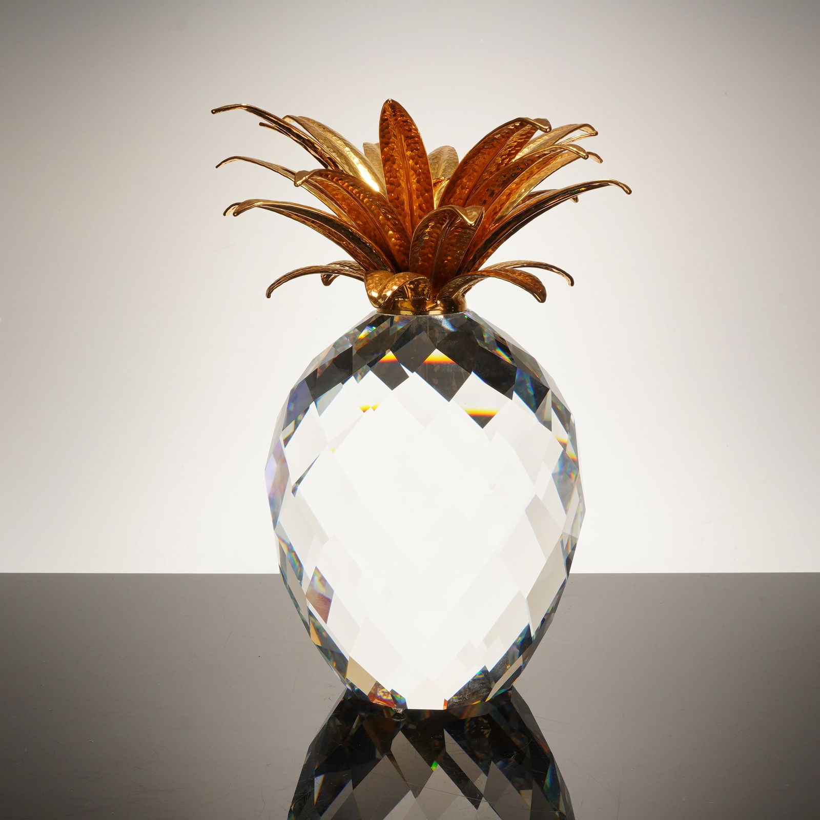 Swarovski Silver Crystal Large Pineapple Figurine with Gold-Toned Leaves: A significant Swarovski crystal figurine from the "Silver Crystal" collection, depicting a stylized pineapple. The ovoid body is meticulously crafted from clear, high-lead content crystal, featuring l