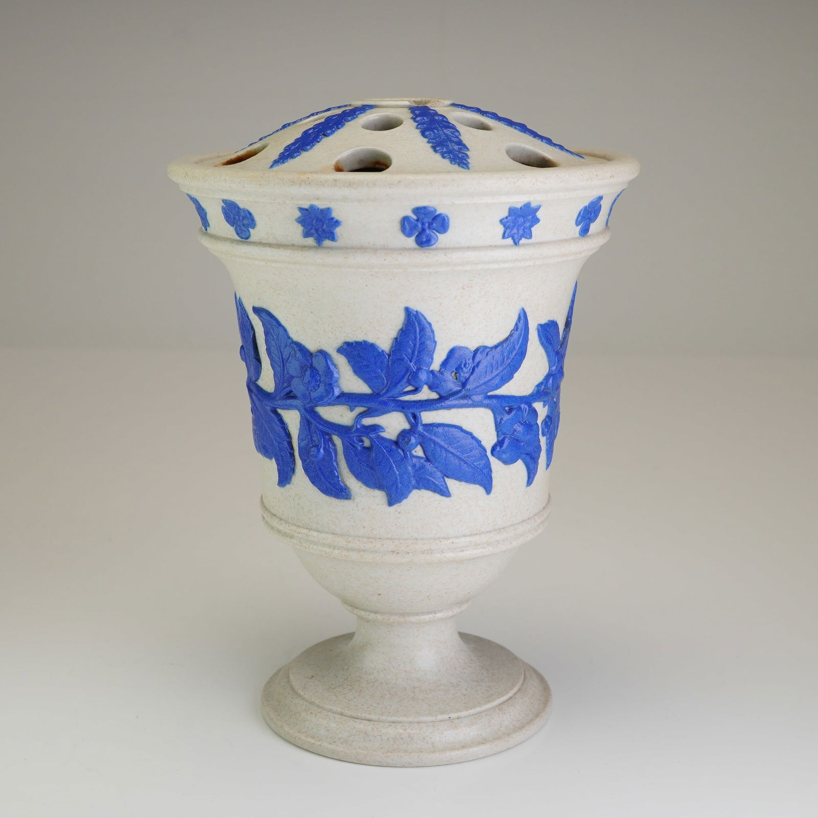 Wedgwood Smear Glazed Stoneware Potpourri Vase: A fine Wedgwood smear-glazed white stoneware potpourri vase of pedestal urn form. The vessel features a light gray, speckled matte body characteristic of the period's stoneware production. It is ornam
