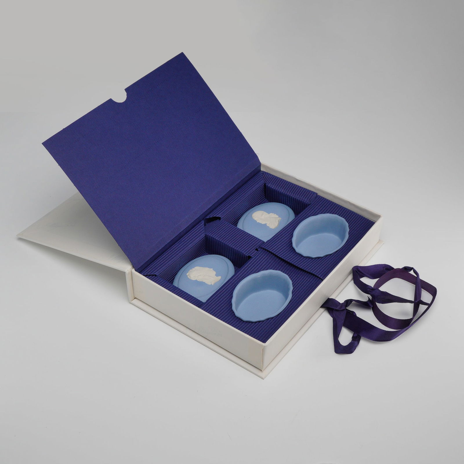 Pair of Wedgwood Blue Jasperware Lidded Oval Treasure Boxes: A pair of Wedgwood pale blue jasperware lidded oval trinket boxes, produced exclusively for The Wedgwood International Society in 1999. These pieces are crafted in the traditional unglazed stoneware b