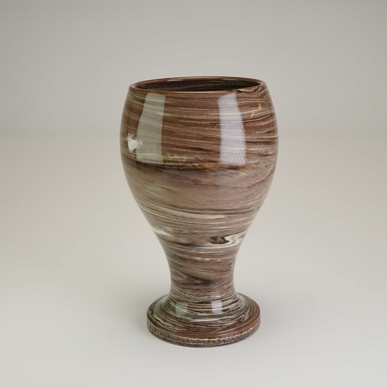 Wedgwood Marbled Jasperware Agate Ware Footed Vase: A small Wedgwood solid agate ware footed vase, featuring a marbled pattern of variegated brown, cream, and white clays finished with a clear, glossy glaze. The vessel is designed with a tapered, bulbo