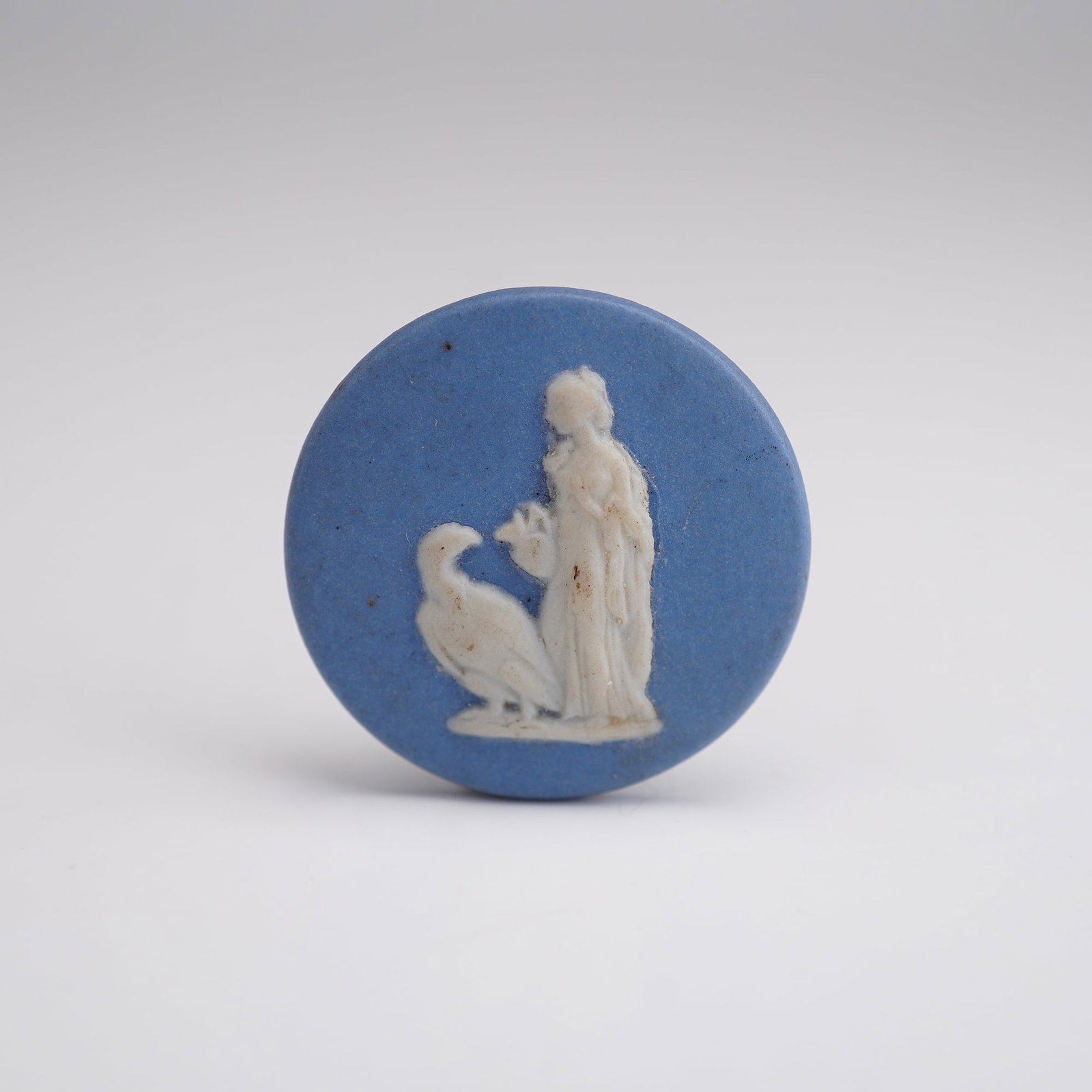 Wedgwood Blue and White Jasperware Plaque of Hebe and Eagle: A tiny circular blue and white Jasperware plaque depicting Hebe feeding the Eagle of Zeus. "Wedgwood" impressed stamp. Dimensions0.75" dia. Manufacturer or BrandWedgwood Country of OriginEngland Weigh