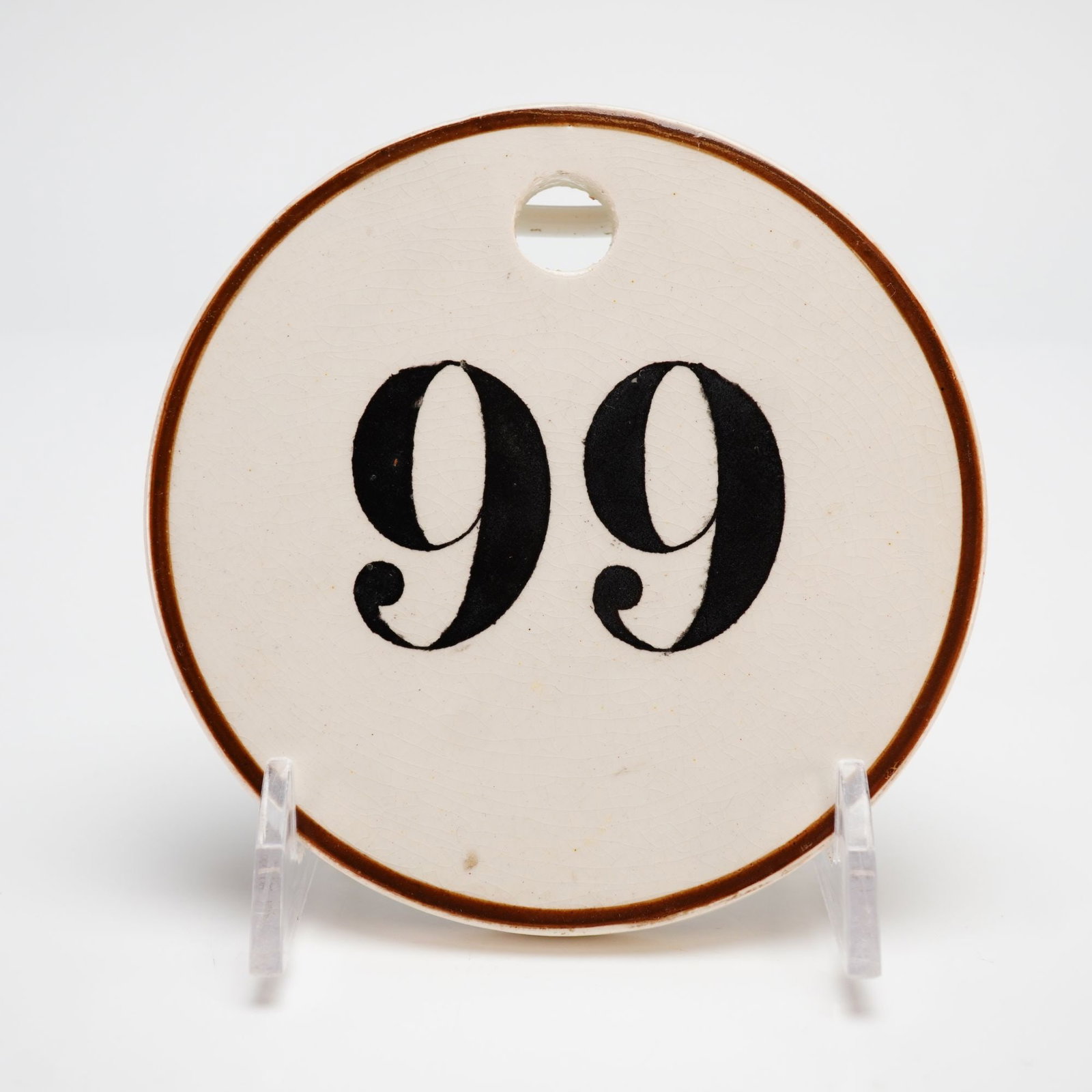 Wedgwood Creamware Numbered Bin Label: This Wedgwood creamware or Queen's ware numbered tag was historically utilized as a bin label for wine cellars or storage organization. The circular ceramic disc features a hand-painted number 99 in b