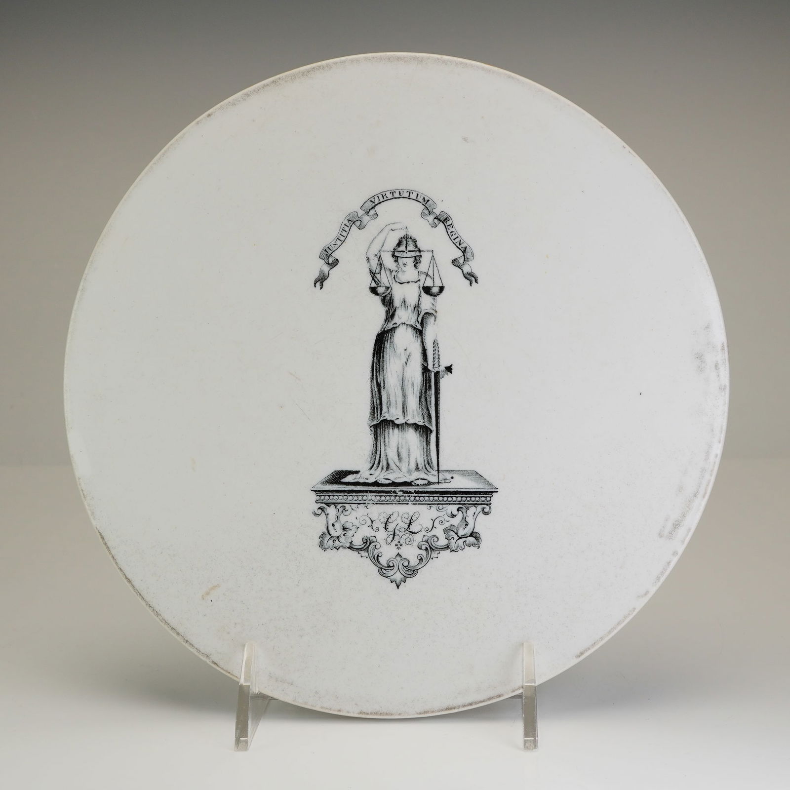 Antique English Ironstone Printed Scale Plate Justitia Virtutum Regina: This circular ironstone scale plate features a central black transfer-printed illustration of Lady Justice. The figure is depicted blindfolded in classical robes, holding a set of scales and a sword w