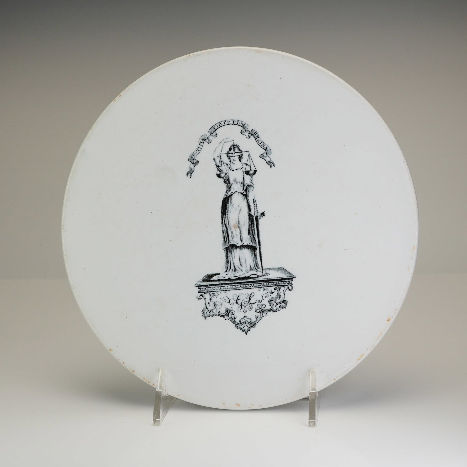 Antique English Ironstone Printed Scale Plate Justitia Virtutum Regina: An antique English ironstone printed scale plate featuring a central black transfer pictorial of Lady Justice. The figure is depicted holding scales and a sword, standing beneath a banner inscribed wi