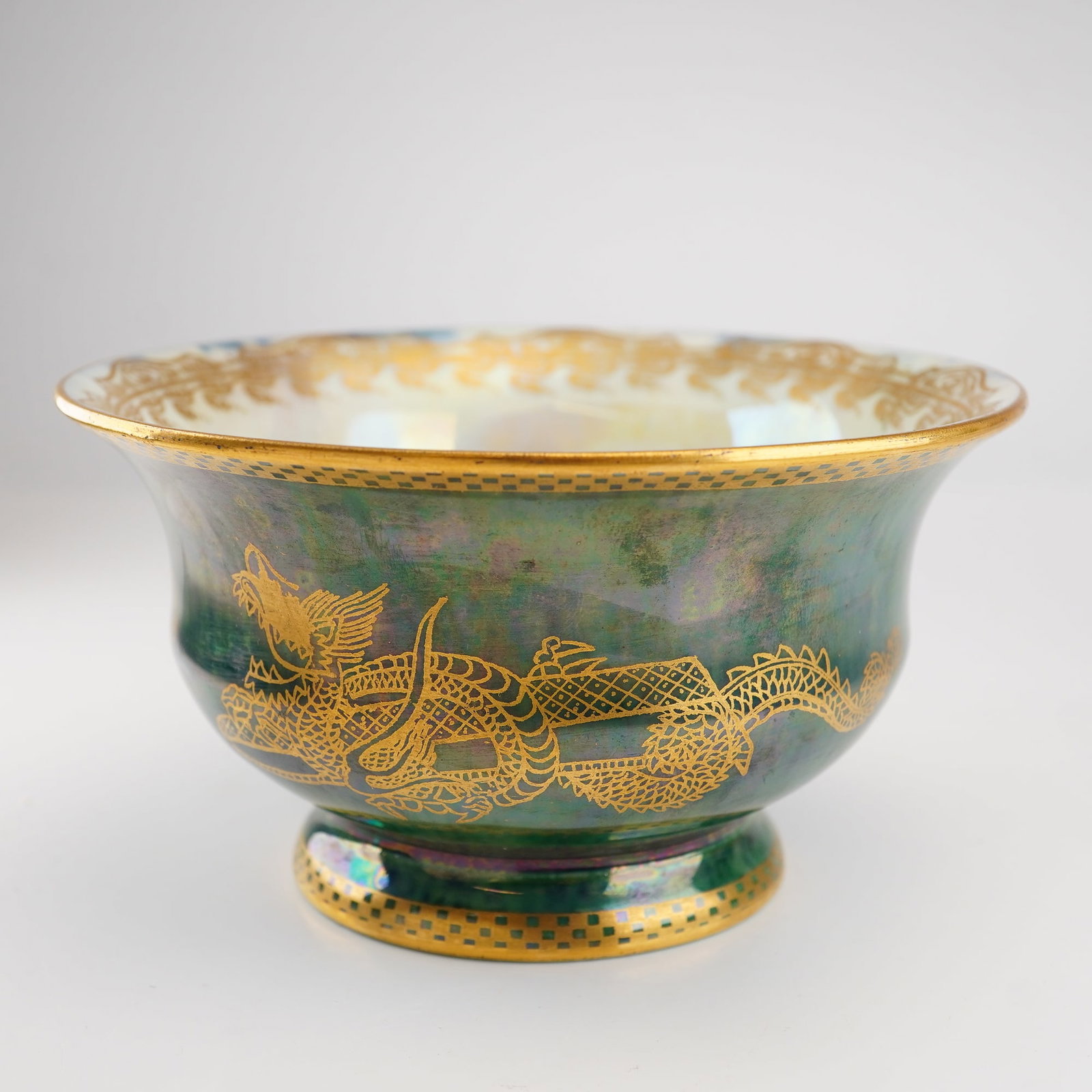 Wedgwood Fairyland Dragon Luster Footed Bowl Z4831: An early 20th-century fine bone china footed bowl designed by Daisy Makeig-Jones for Wedgwood. The exterior is decorated in a mottled deep green iridescent luster glaze featuring hand-applied gold-gil