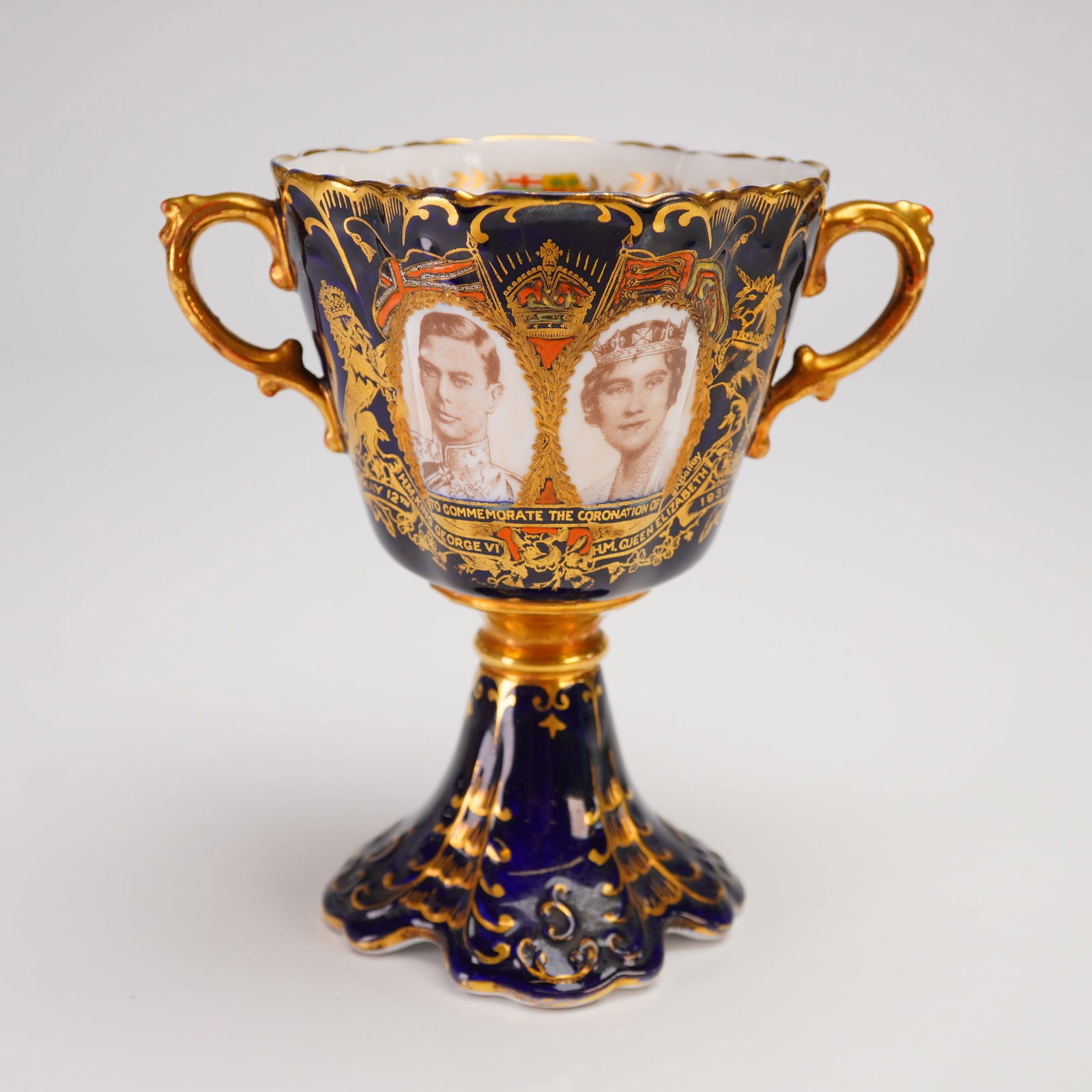 Aynsley Bone China King George VI Coronation Cup: A single Aynsley bone china porcelain coronation cup, designed as a two-handled loving cup or goblet, commemorating the Coronation of King George VI and Queen Elizabeth in 1937. The vessel features a