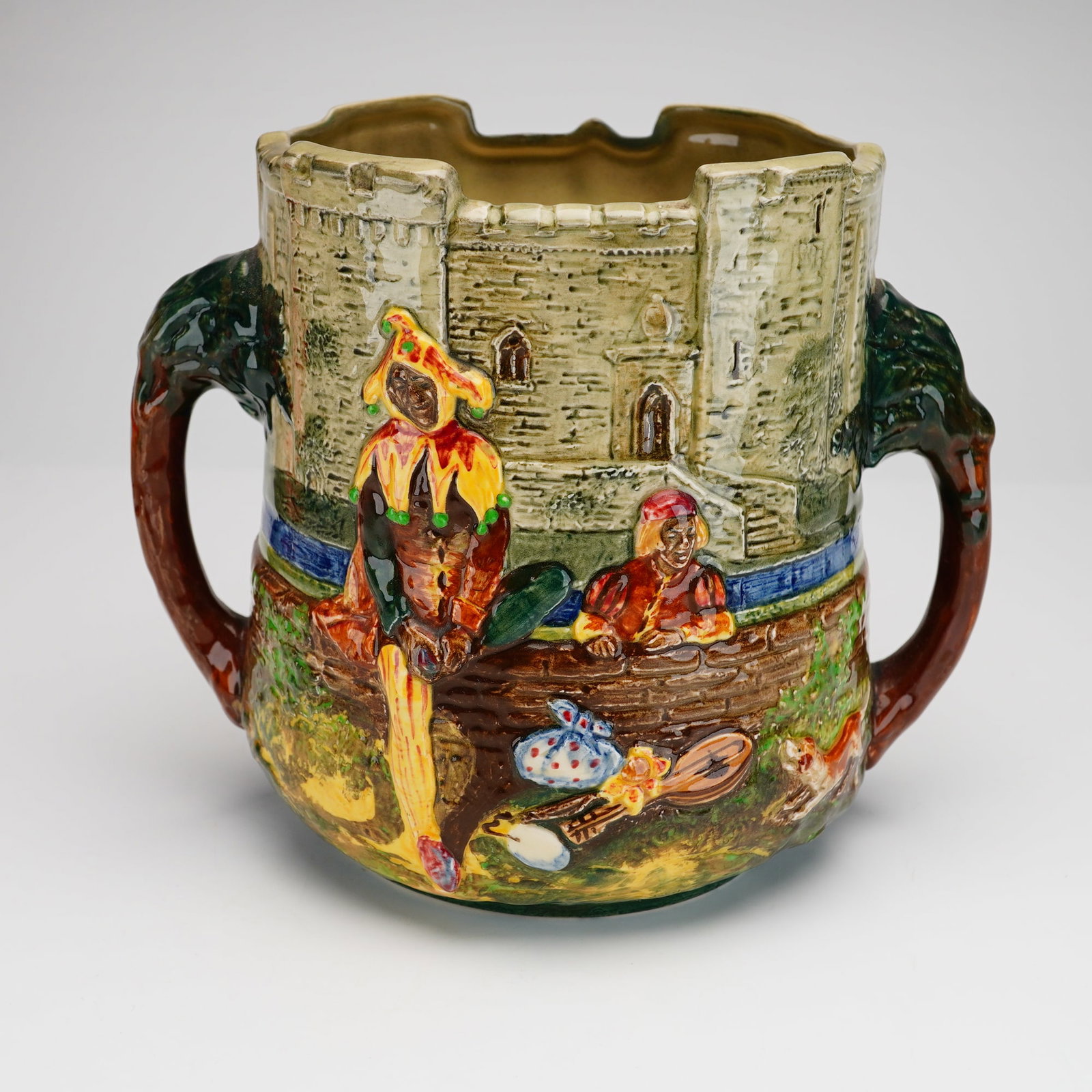 Royal Doulton Presentation Loving Cup The Wandering Minstrel: A Royal Doulton earthenware loving cup designed by Charles Noke and Harry Fenton. This limited-edition, 227 of 600, vessel features high-relief polychrome decoration inspired by the Gilbert and Sulliv