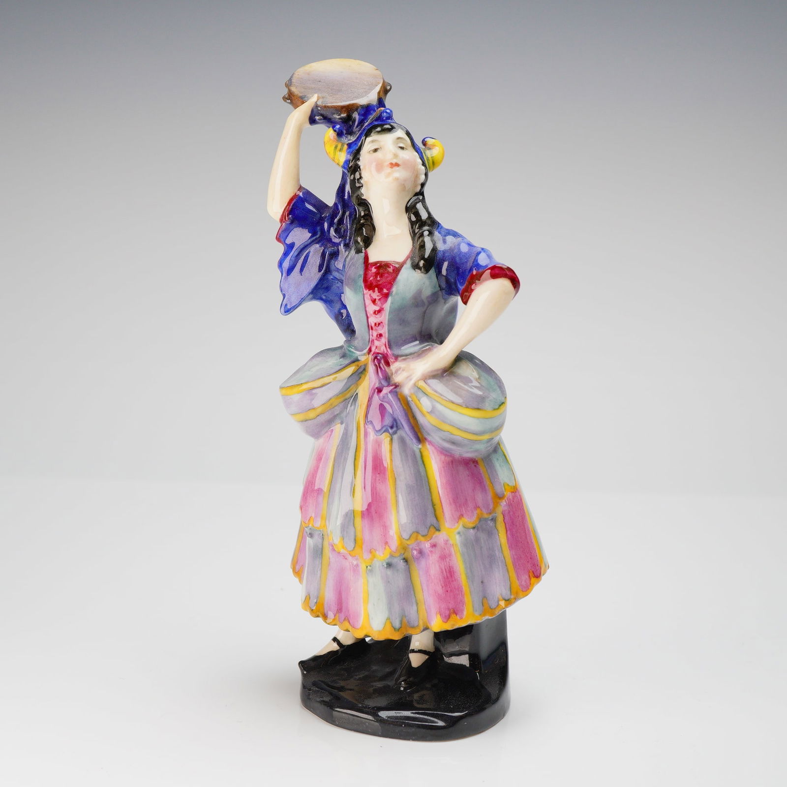 Royal Doulton Elsie Maynard HN 639 Glazed Ceramic Figurine: A Royal Doulton glazed ceramic figurine titled Elsie Maynard, model number HN 639. The figurine depicts a female performing figure modeled in a dramatic pose, standing on a dark, octagonal base. She w